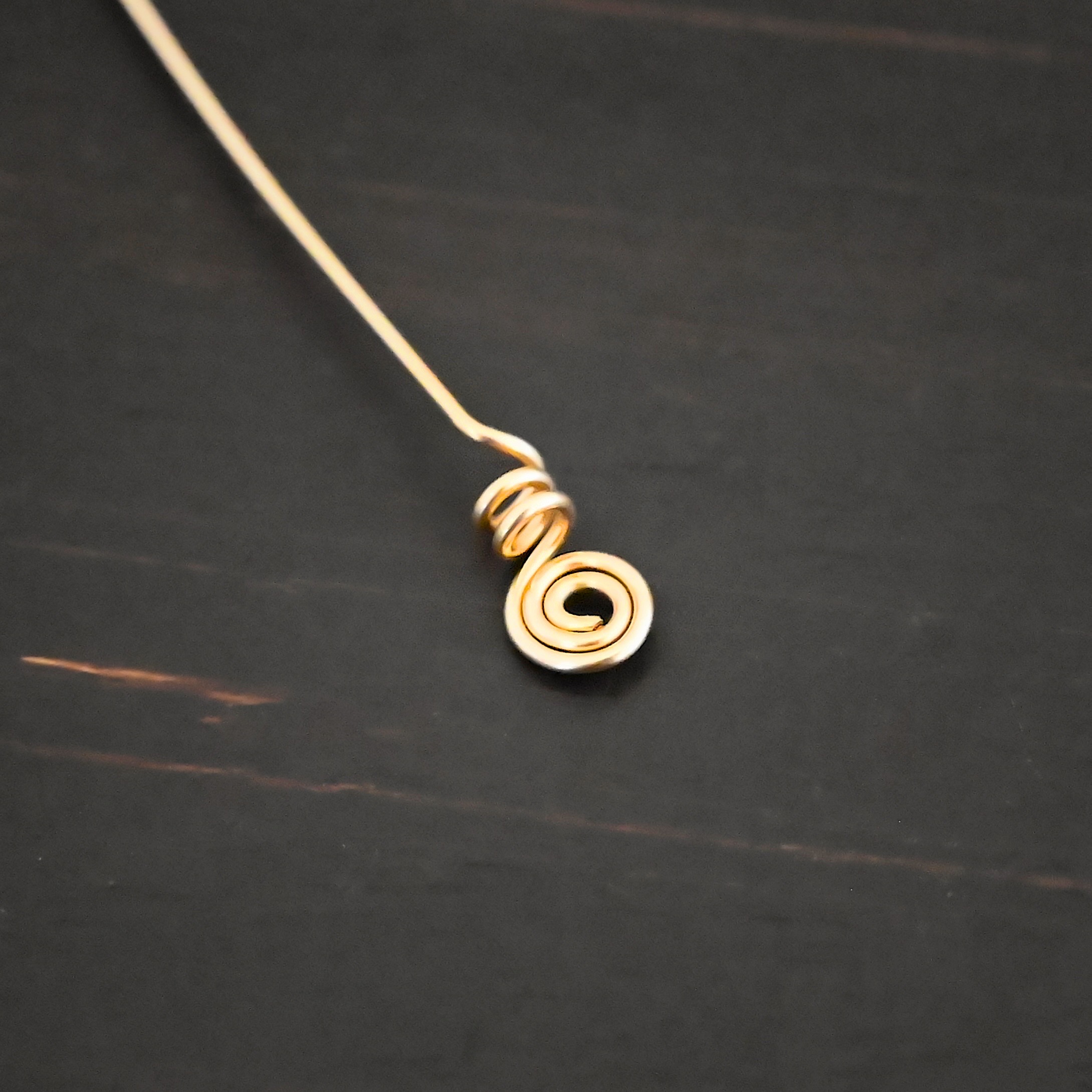 Gold Filled swirl headpin shown on dark background