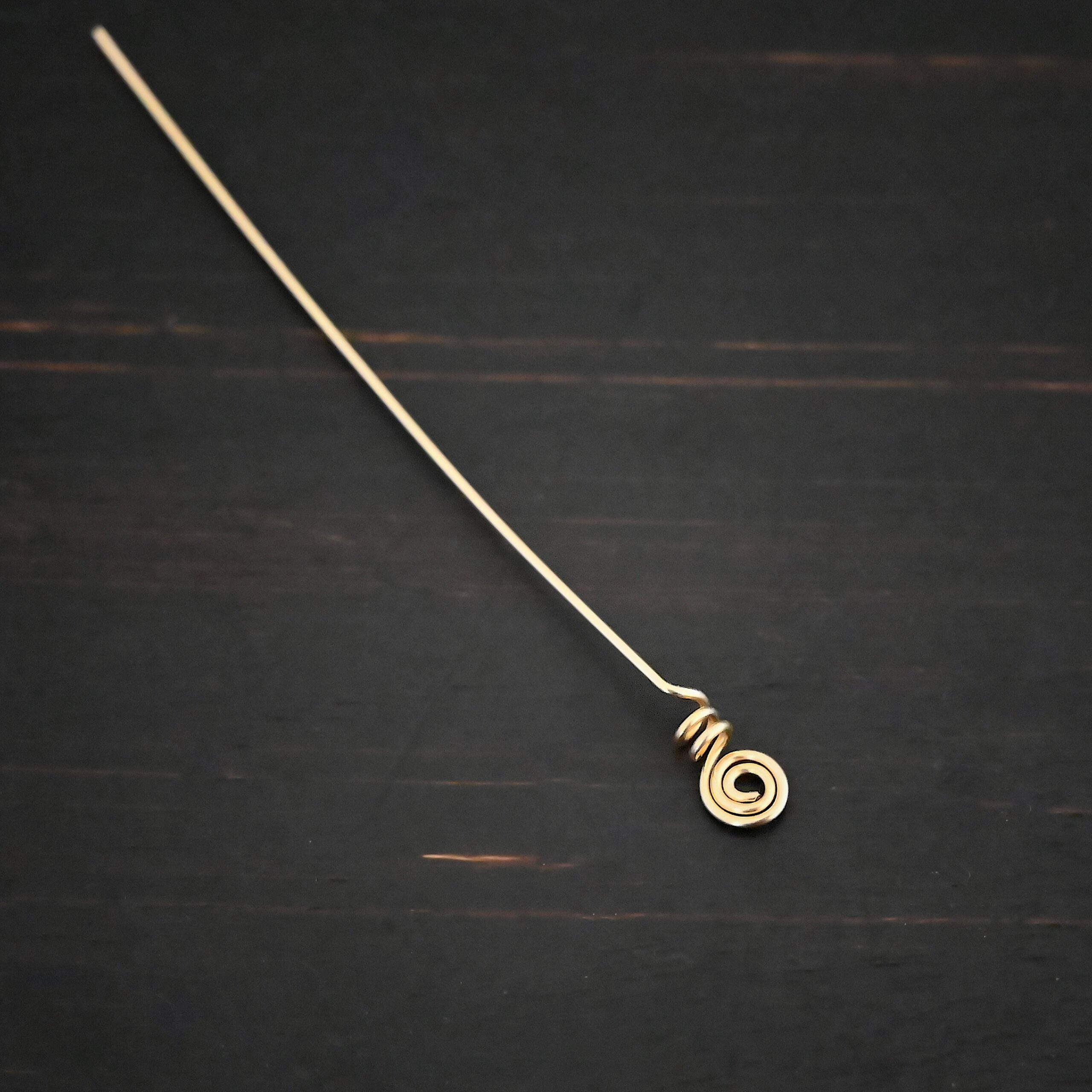 Gold Filled swirl headpin shown on dark background