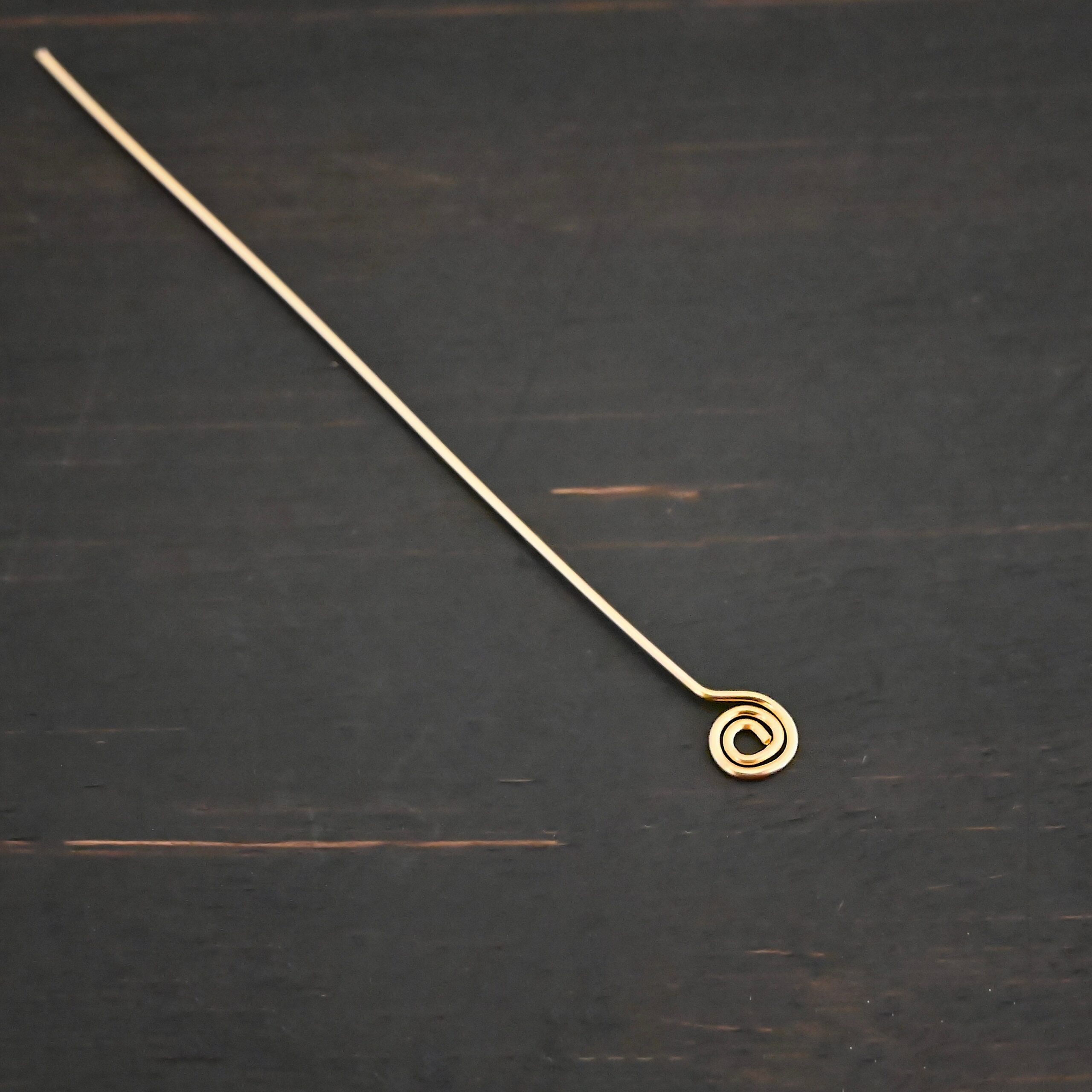 Gold Filled Swirl headpin shown on dark background