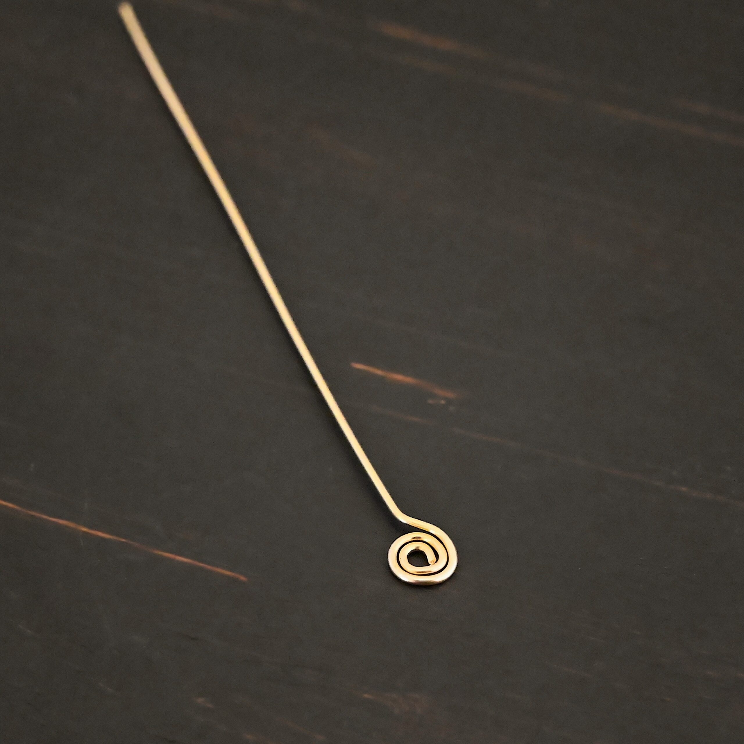 Gold Filled Swirl headpin shown on dark background
