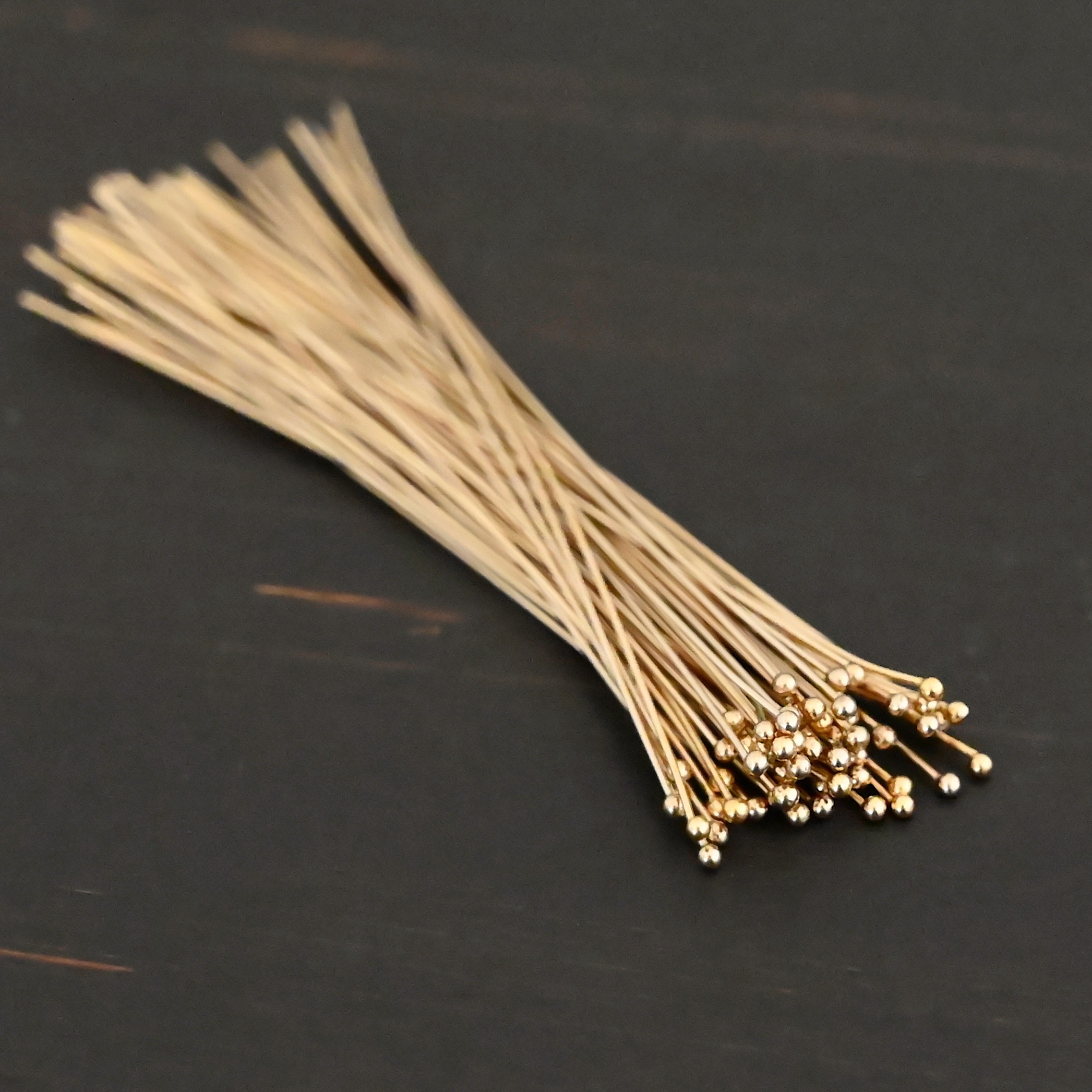 Gold Filled Ball Headpins shown on dark background