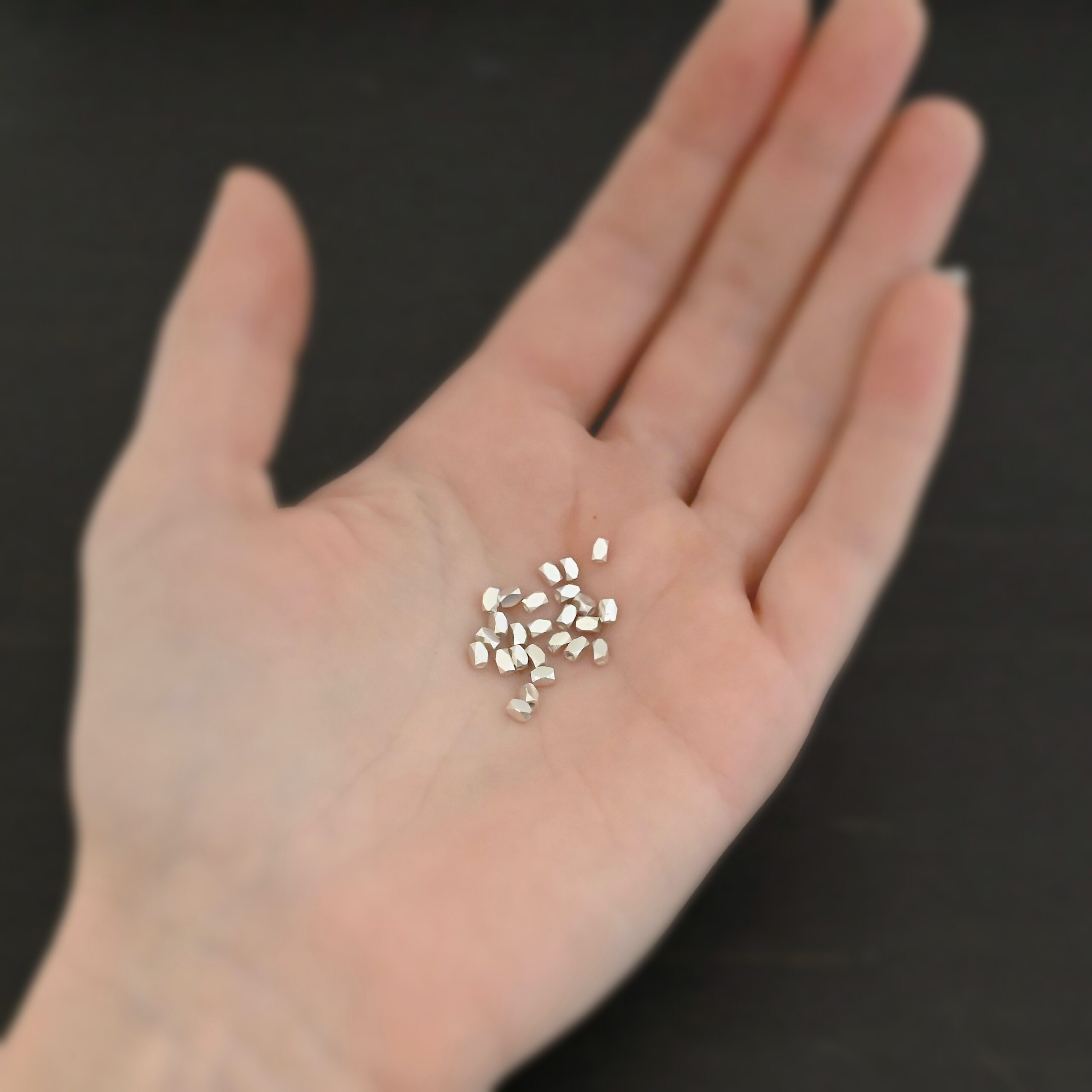 Silver shiny rectangle Beads shown in hand