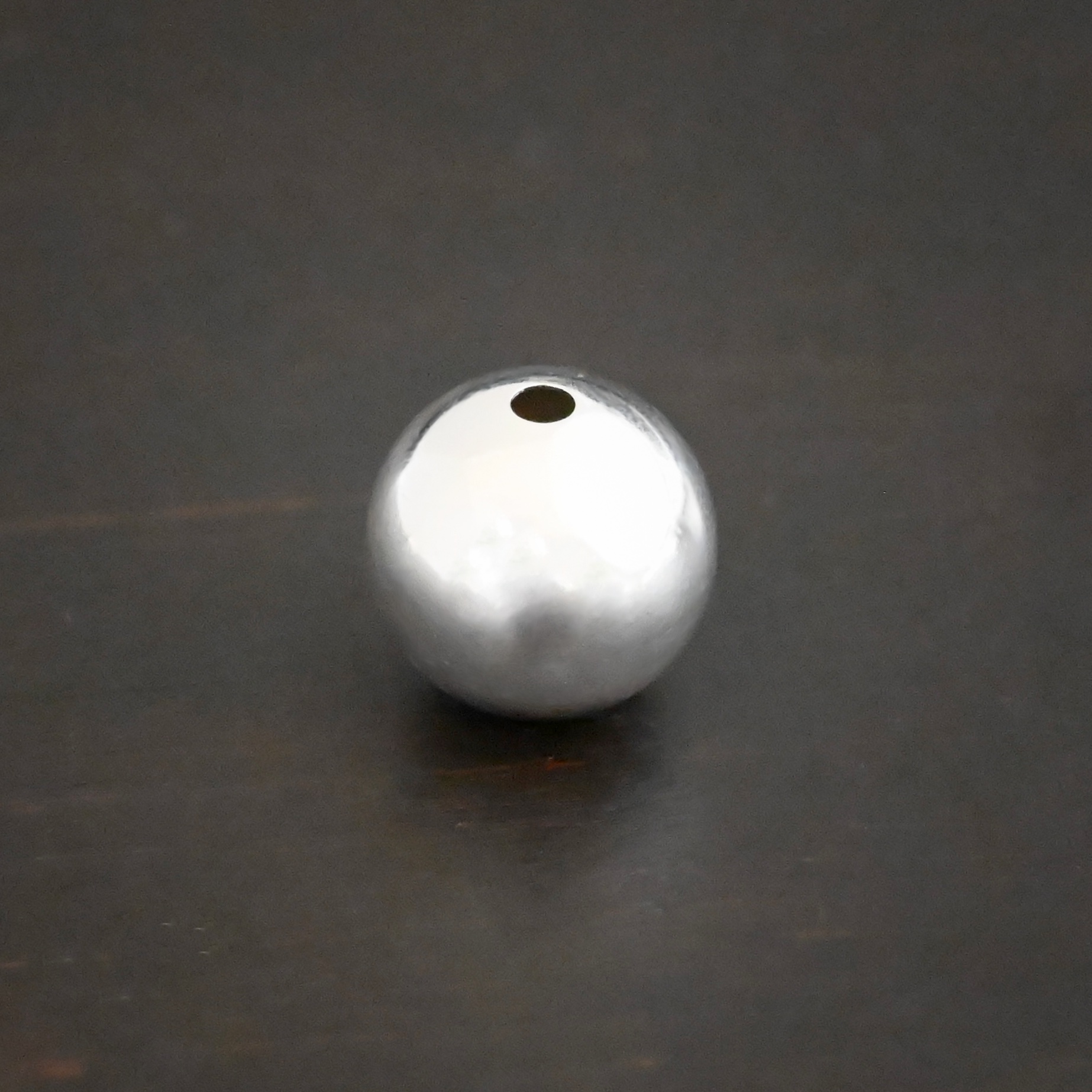 Silver Shiny Hollow bead shown on dark background