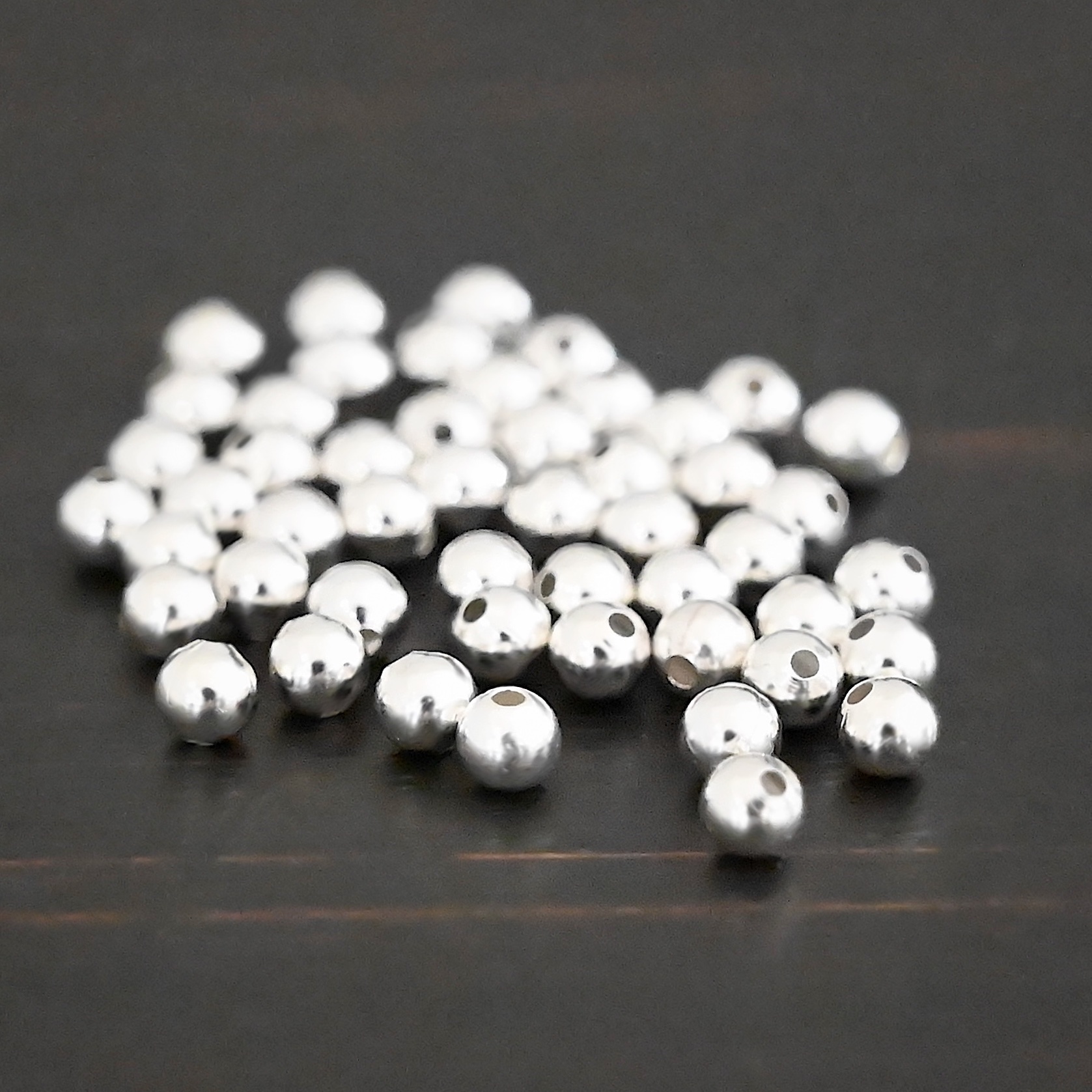 Silver Shiny Hollow beads shown on dark background
