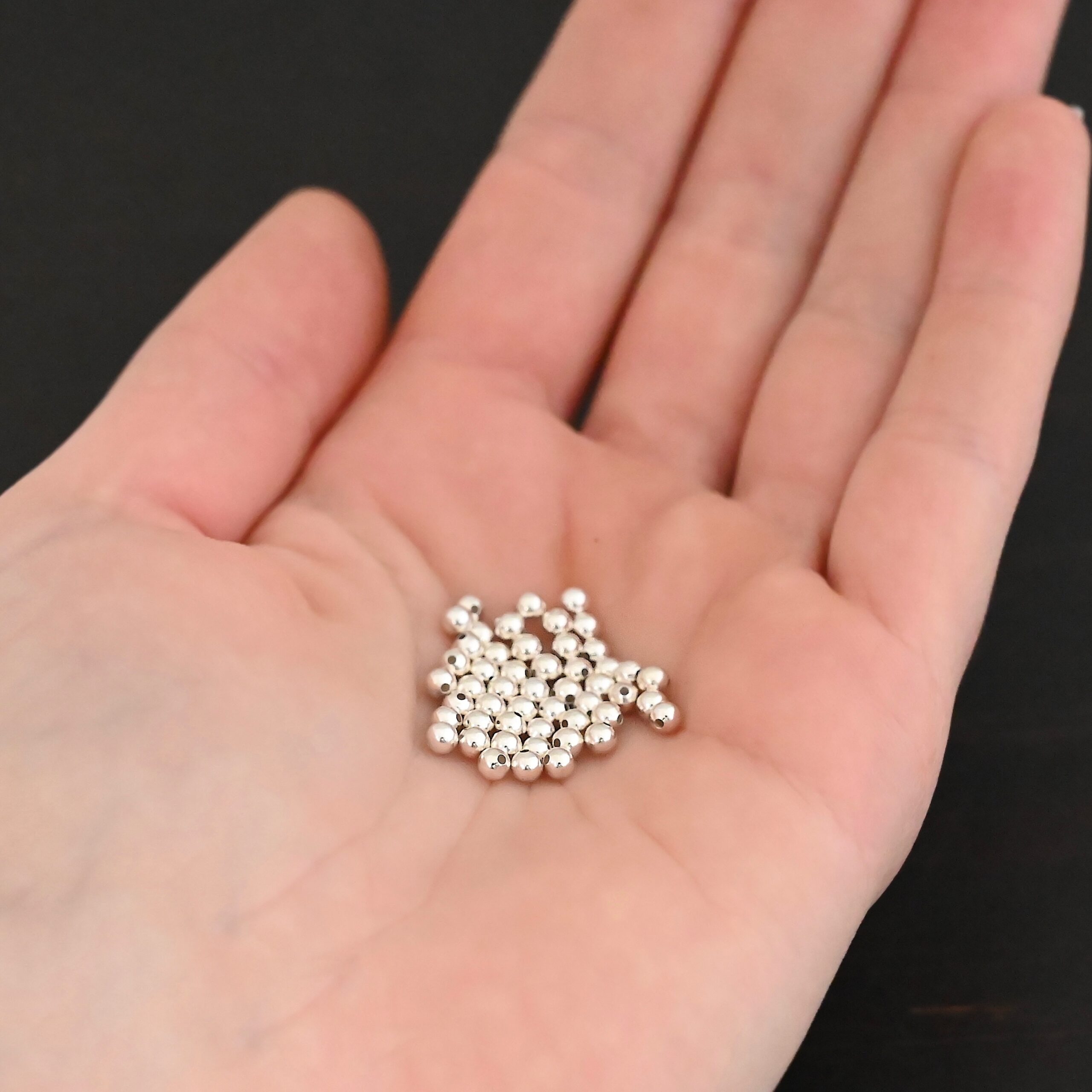 Silver Shiny Hollow beads shown in hand