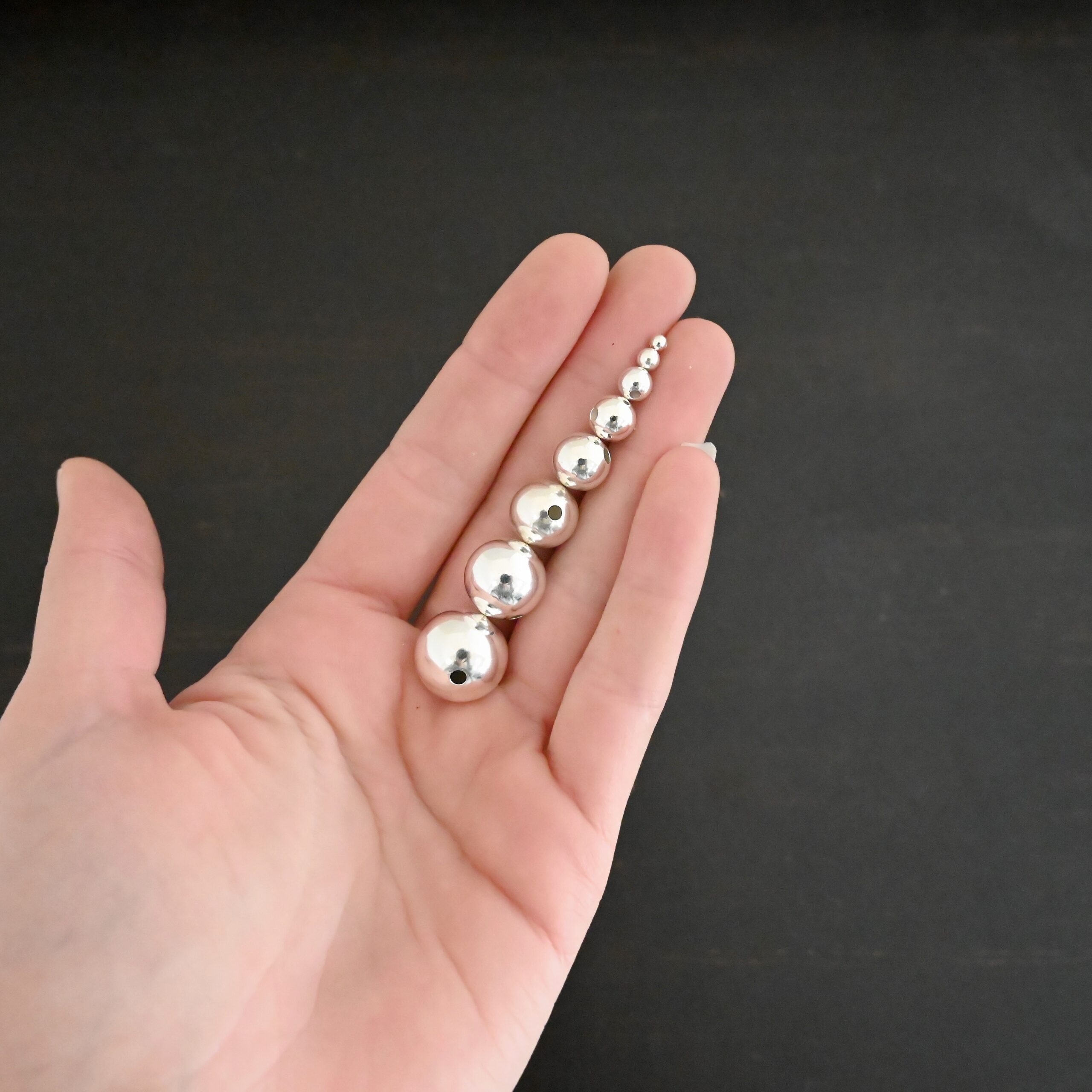 Silver Shiny Hollow beads shown in hand