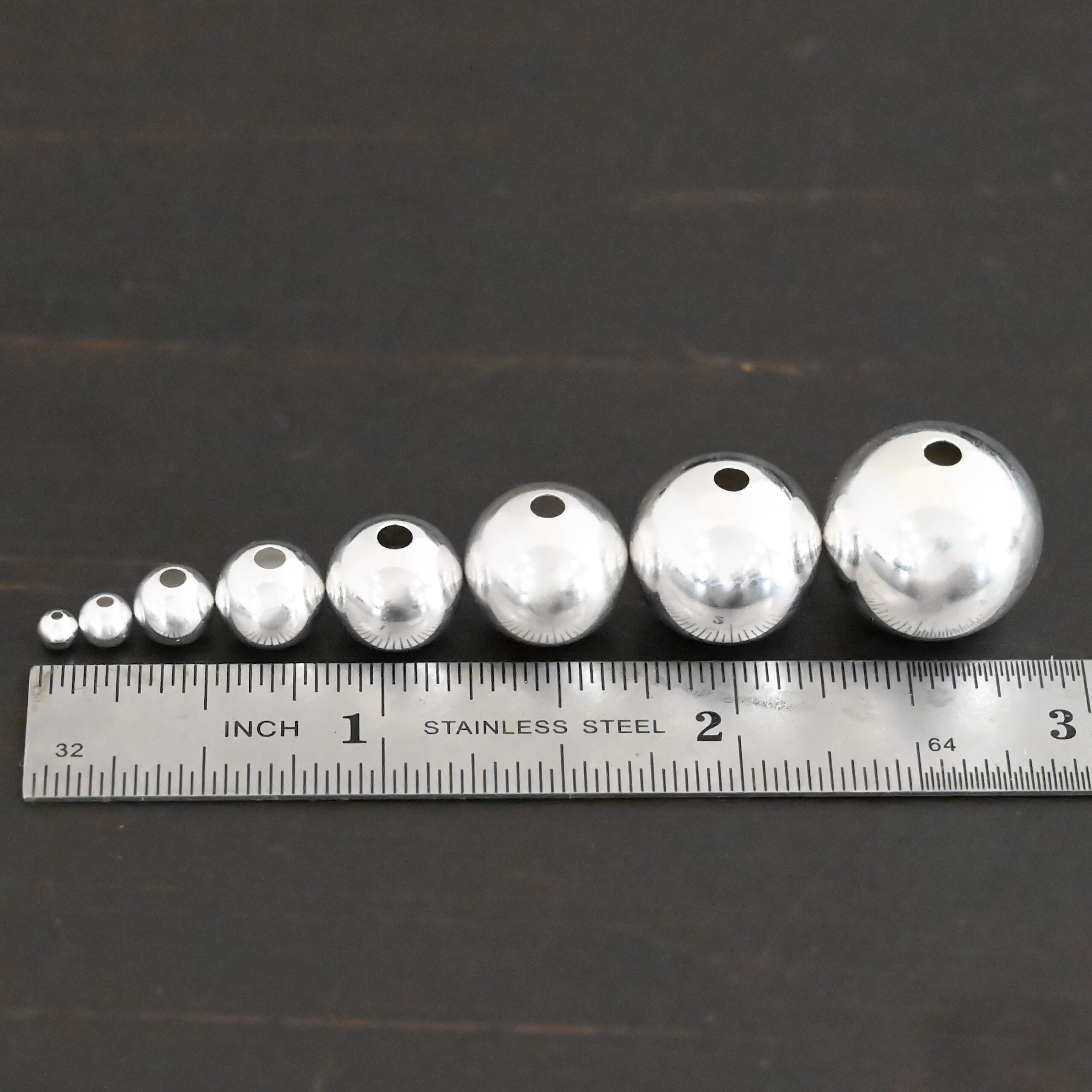 Silver Shiny Hollow beads shown by ruler