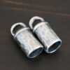 Handmade silver oxidized end caps on dark background