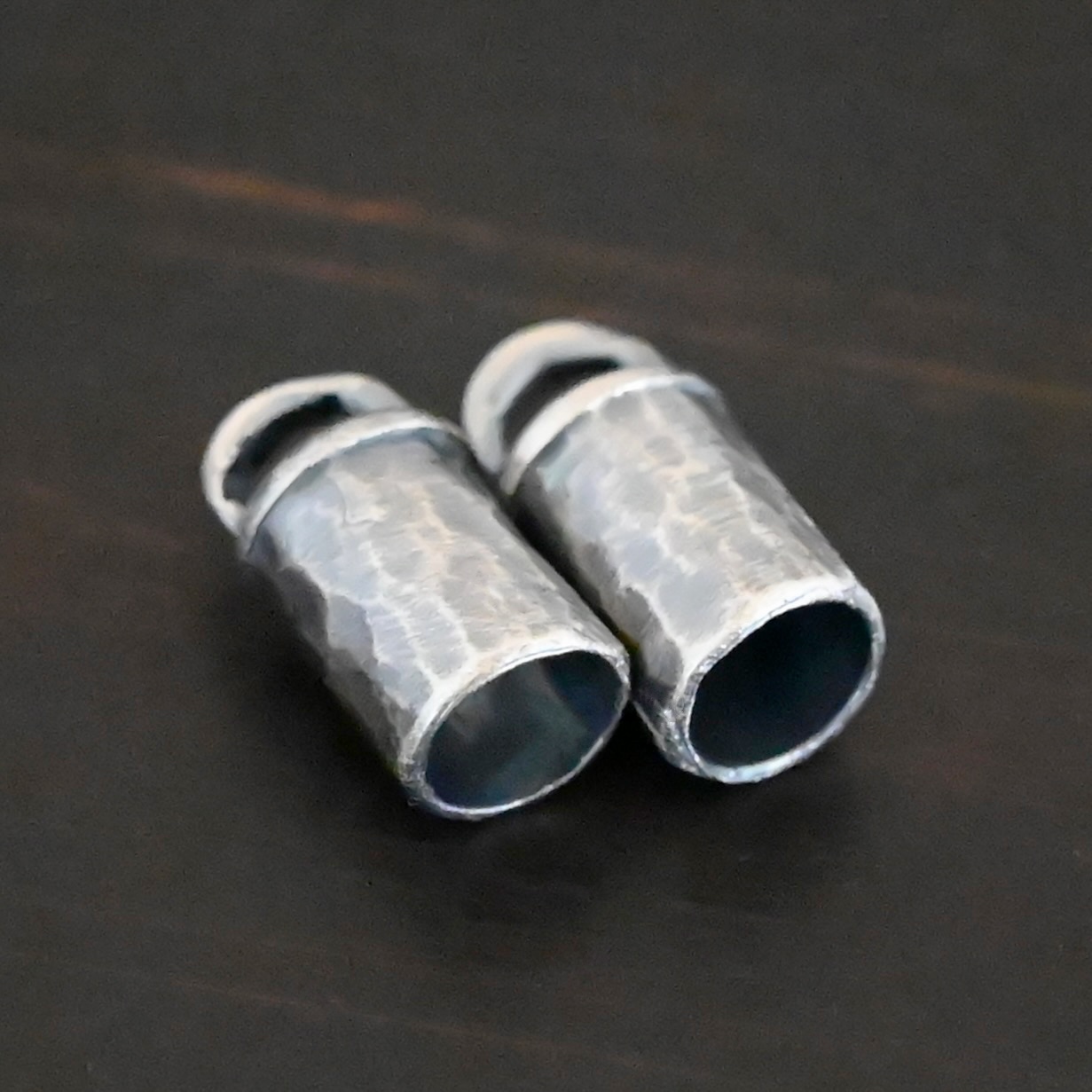Handmade End Caps Handmade silver oxidized end caps on dark background