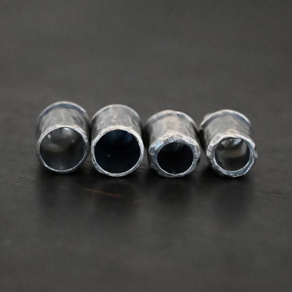Handmade silver oxidized end caps on dark background