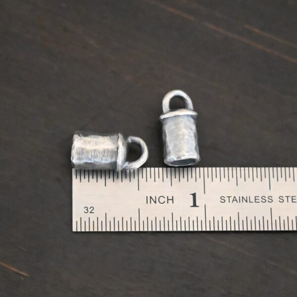 Handmade silver 5mm oxidized end caps shown by ruler