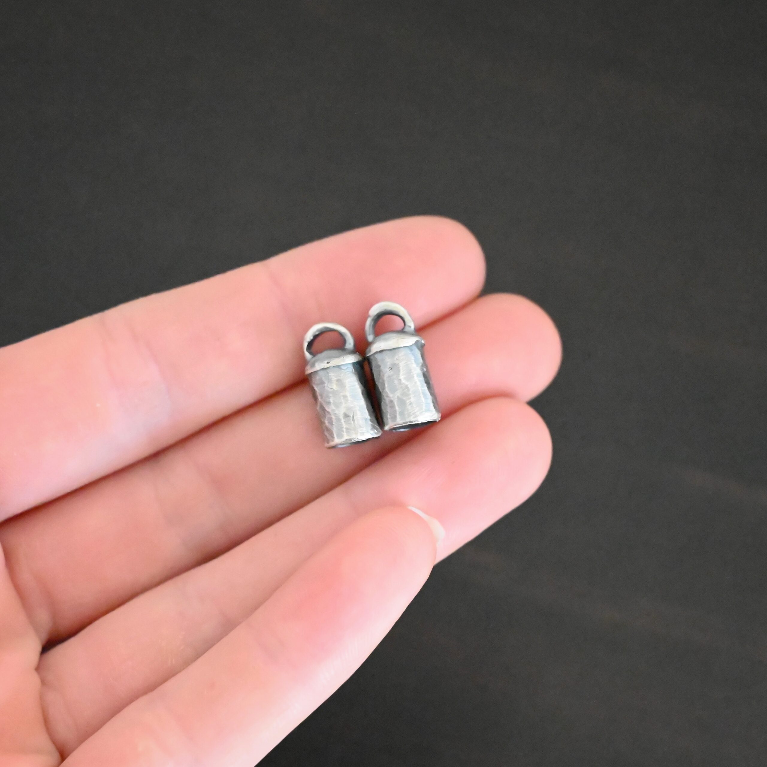 Handmade 6mm End Caps Handmade silver 6mm oxidized end caps shown in hand