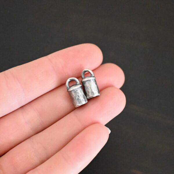 Handmade silver 5mm oxidized end caps shown in hand