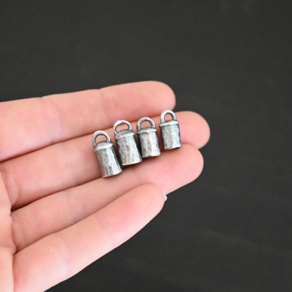 Handmade silver oxidized end caps shown in hand