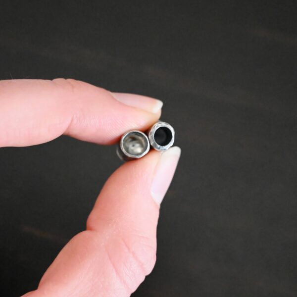 Handmade silver oxidized end caps shown in hand