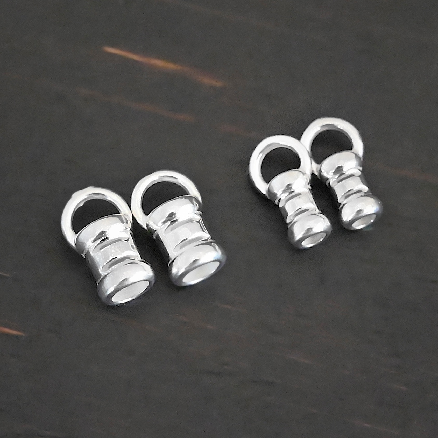 Silver shiny 2mm & 3mm crimps shown on dark background