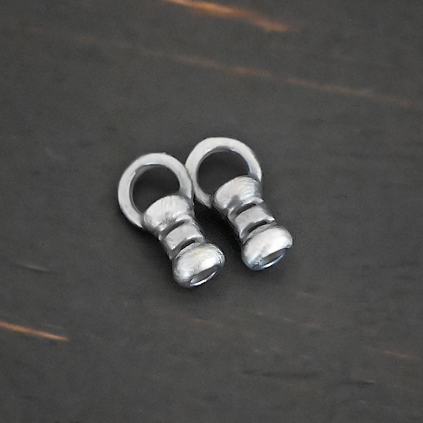 Silver oxidized 2mm crimps shown on dark background