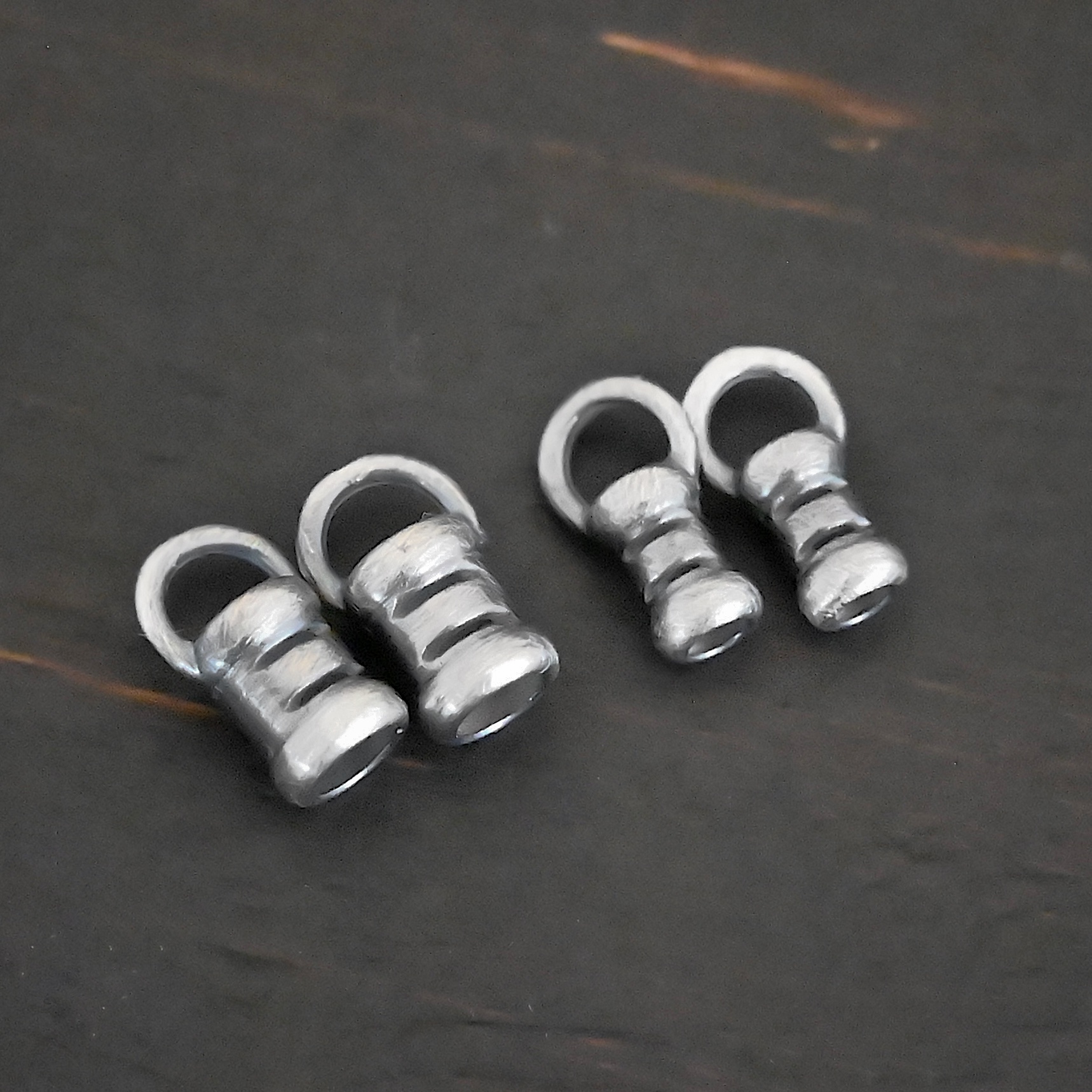 Silver oxidized 3mm & 2mm crimps shown on dark background