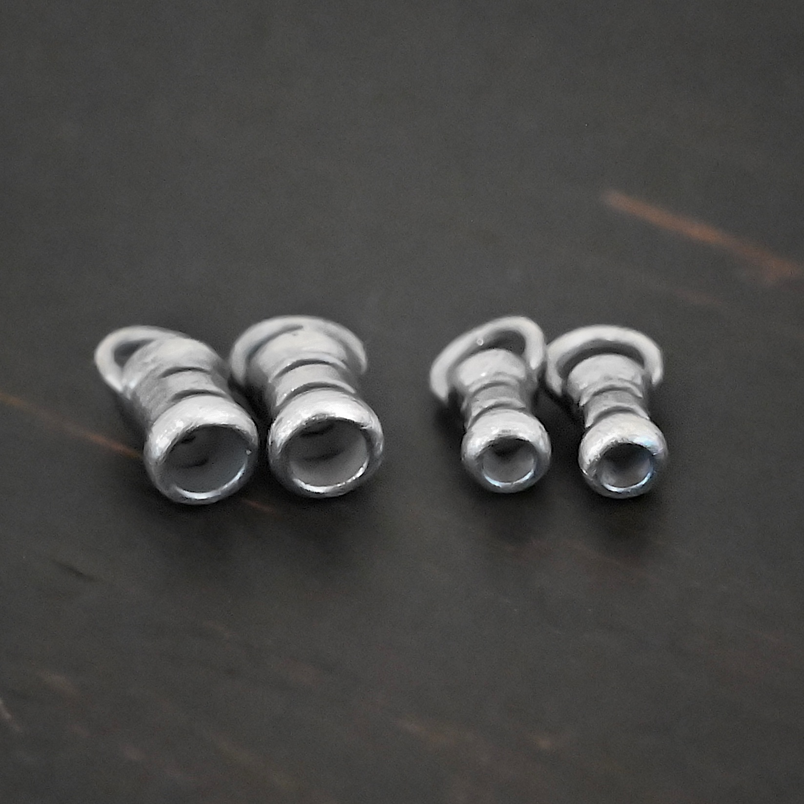 Silver oxidized 3mm & 2mm crimps shown on dark background