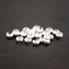 Silver shiny crimp covers shown on dark background
