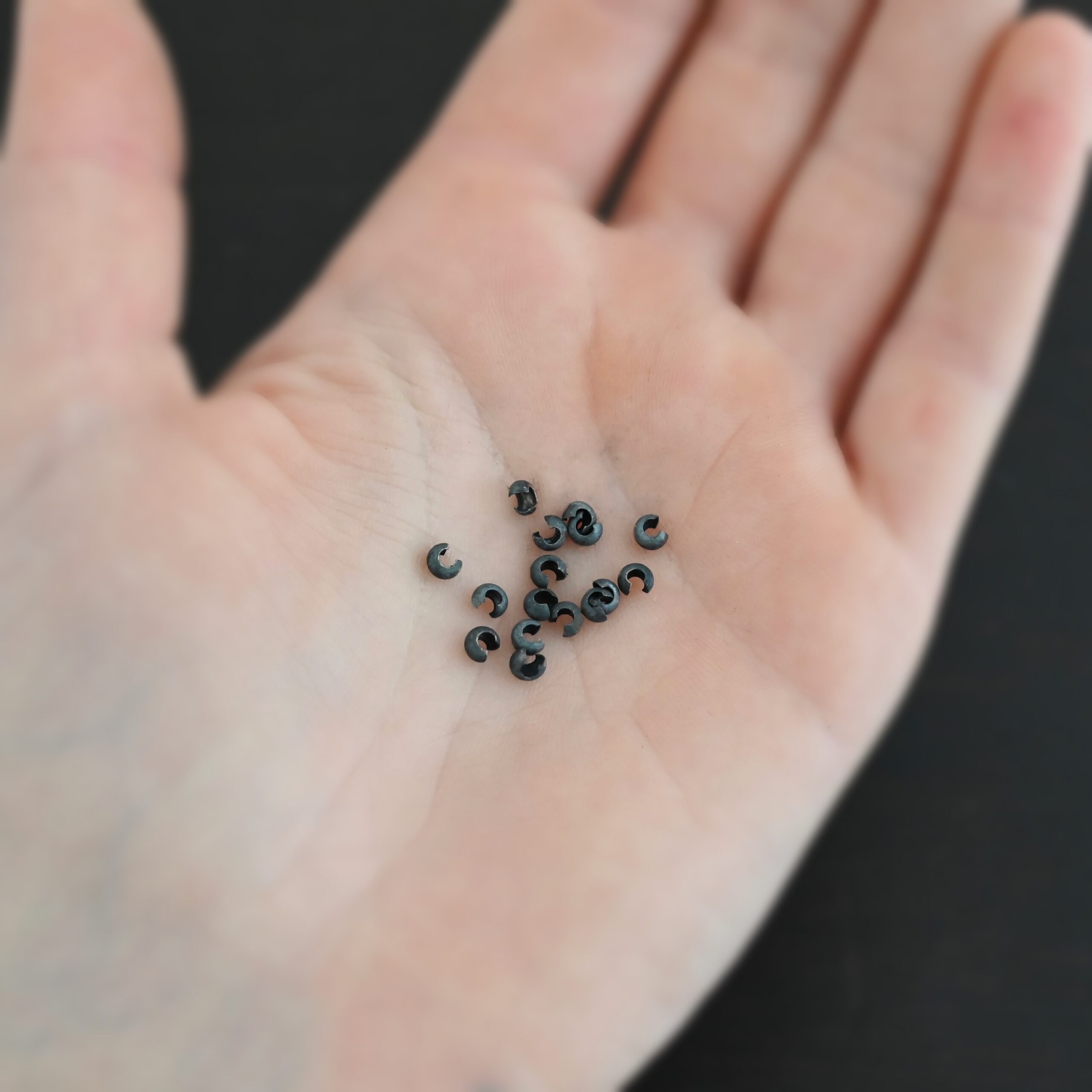 Silver oxidized 3mm crimp covers shown in hand