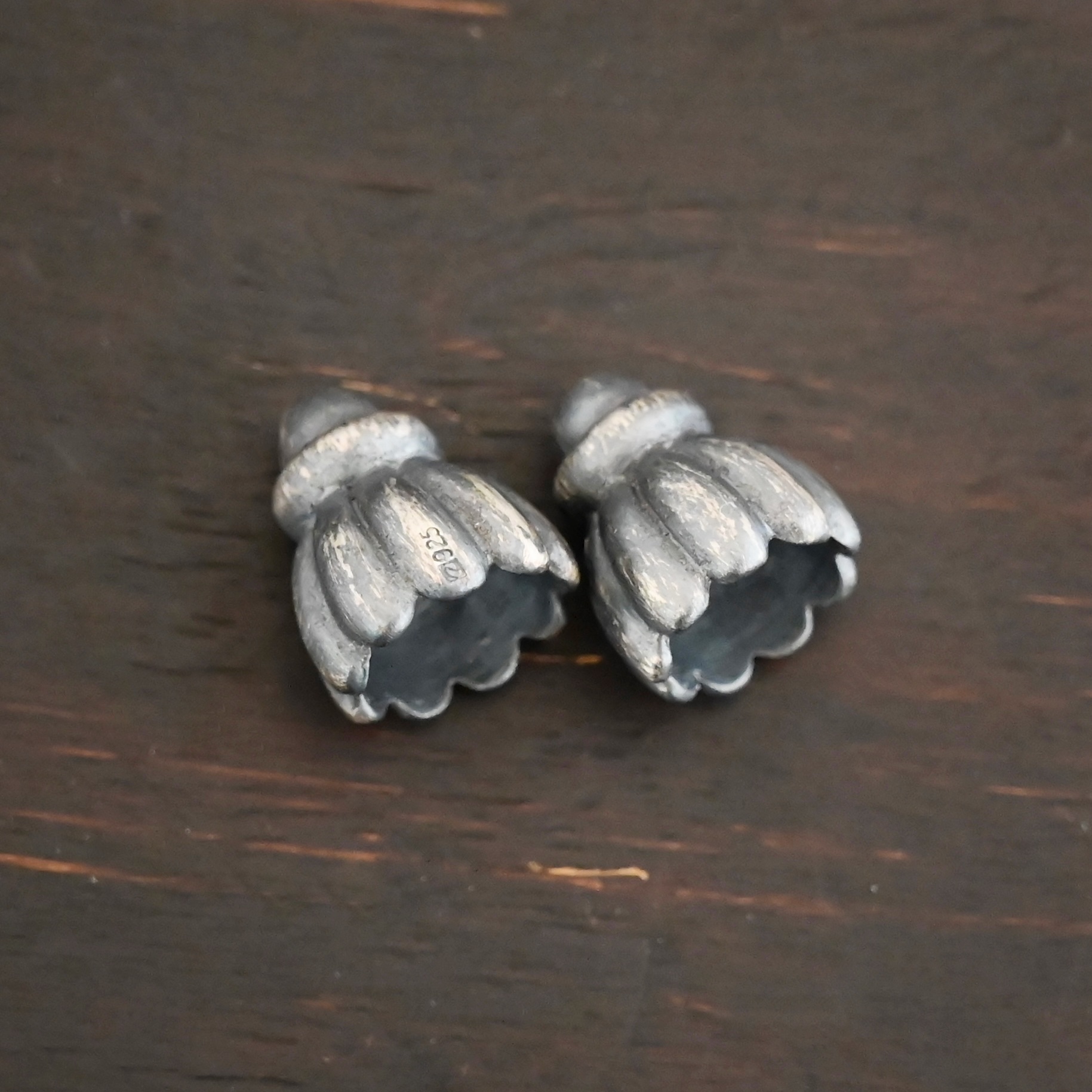 Silver oxidized cone flower bead cap shown on dark background