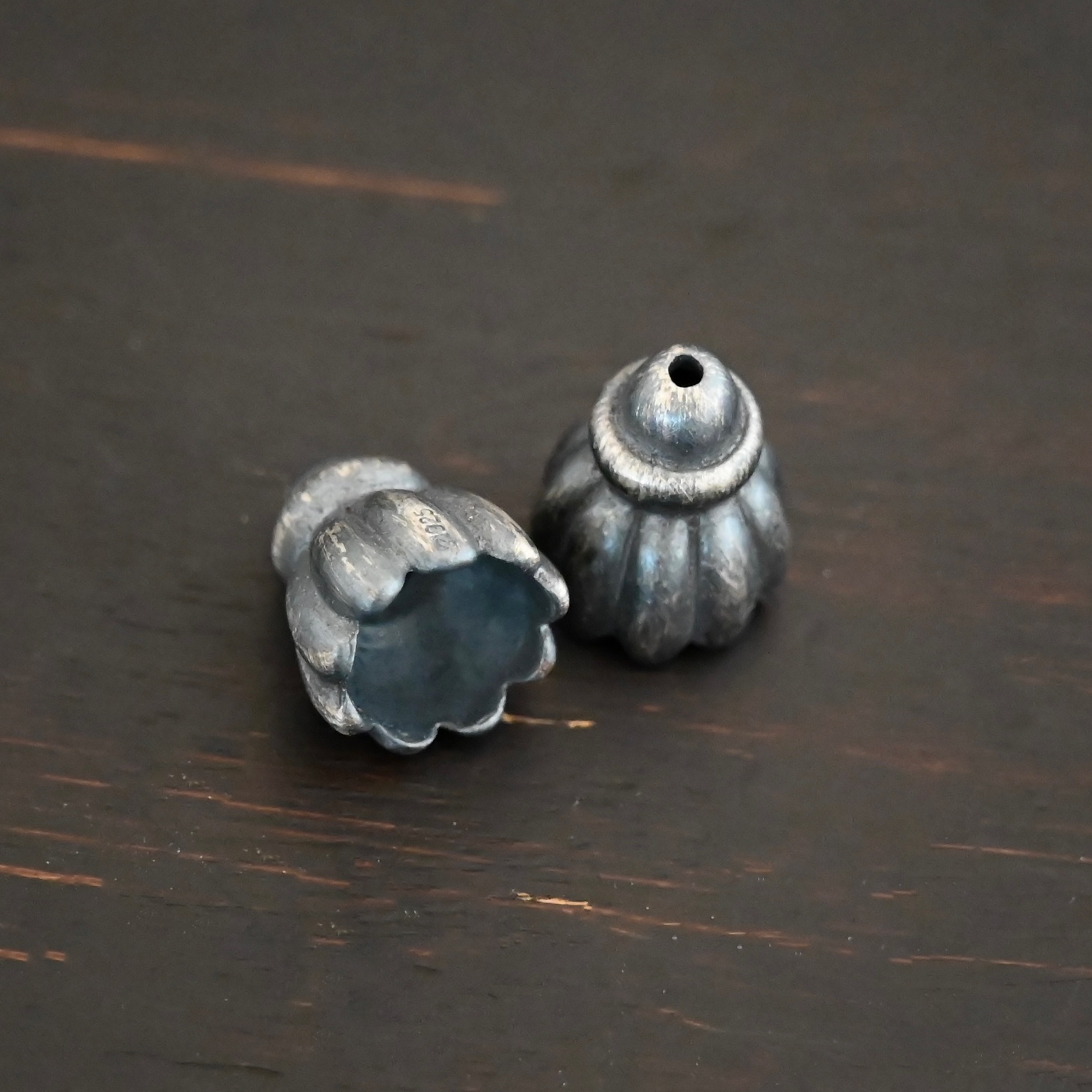Silver oxidized cone flower bead cap shown on dark background