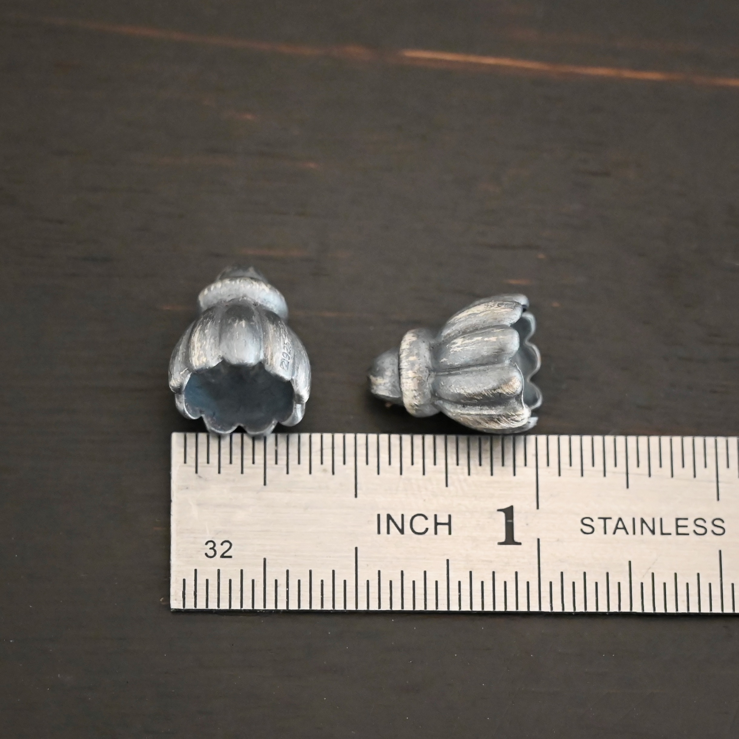 Silver oxidized cone flower bead cap shown by ruler