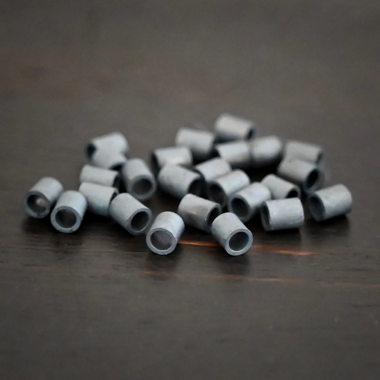 Silver oxidized 3mm crimps shown on dark background