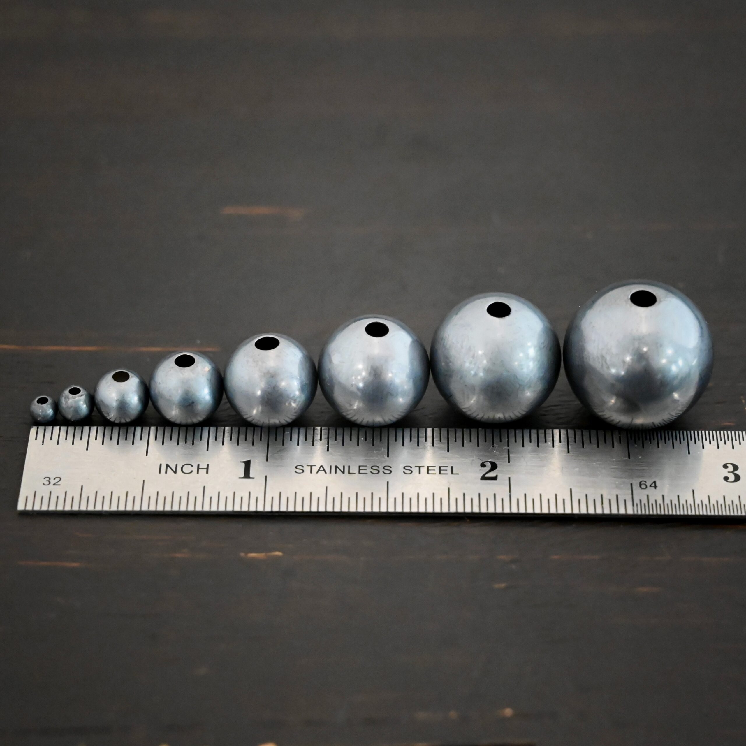 Silver oxidized hollow beads shown by ruler