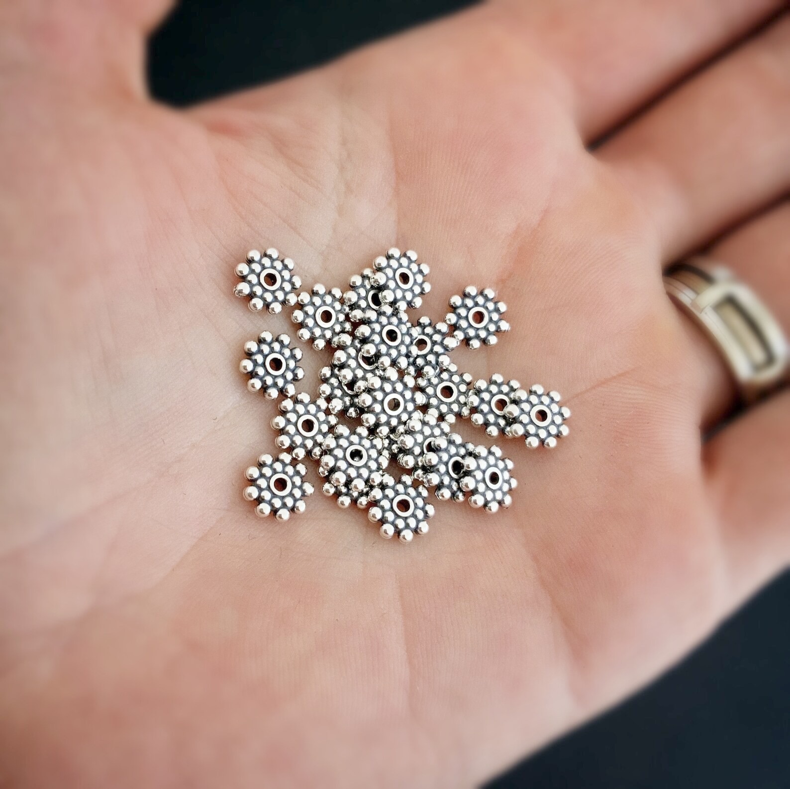 Silver 7mm daisy spacer shown in hand