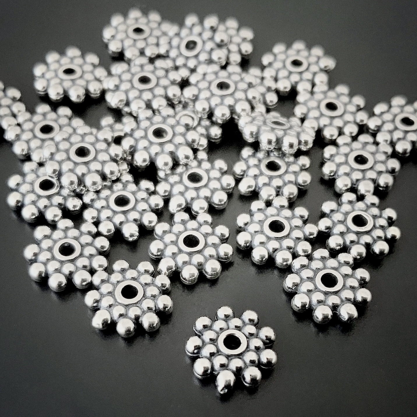 Silver 7mm daisy spacer on dark background
