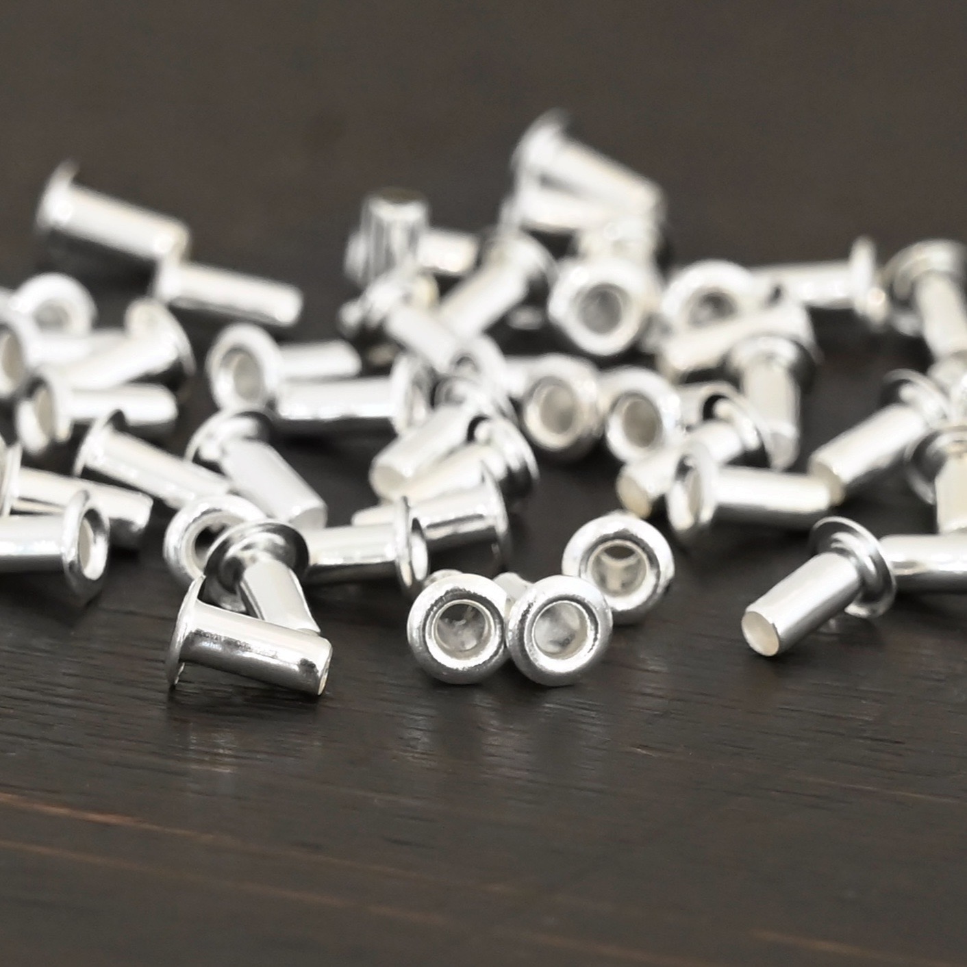 3/32x1/5 Silver plated eyelets shown on dark background