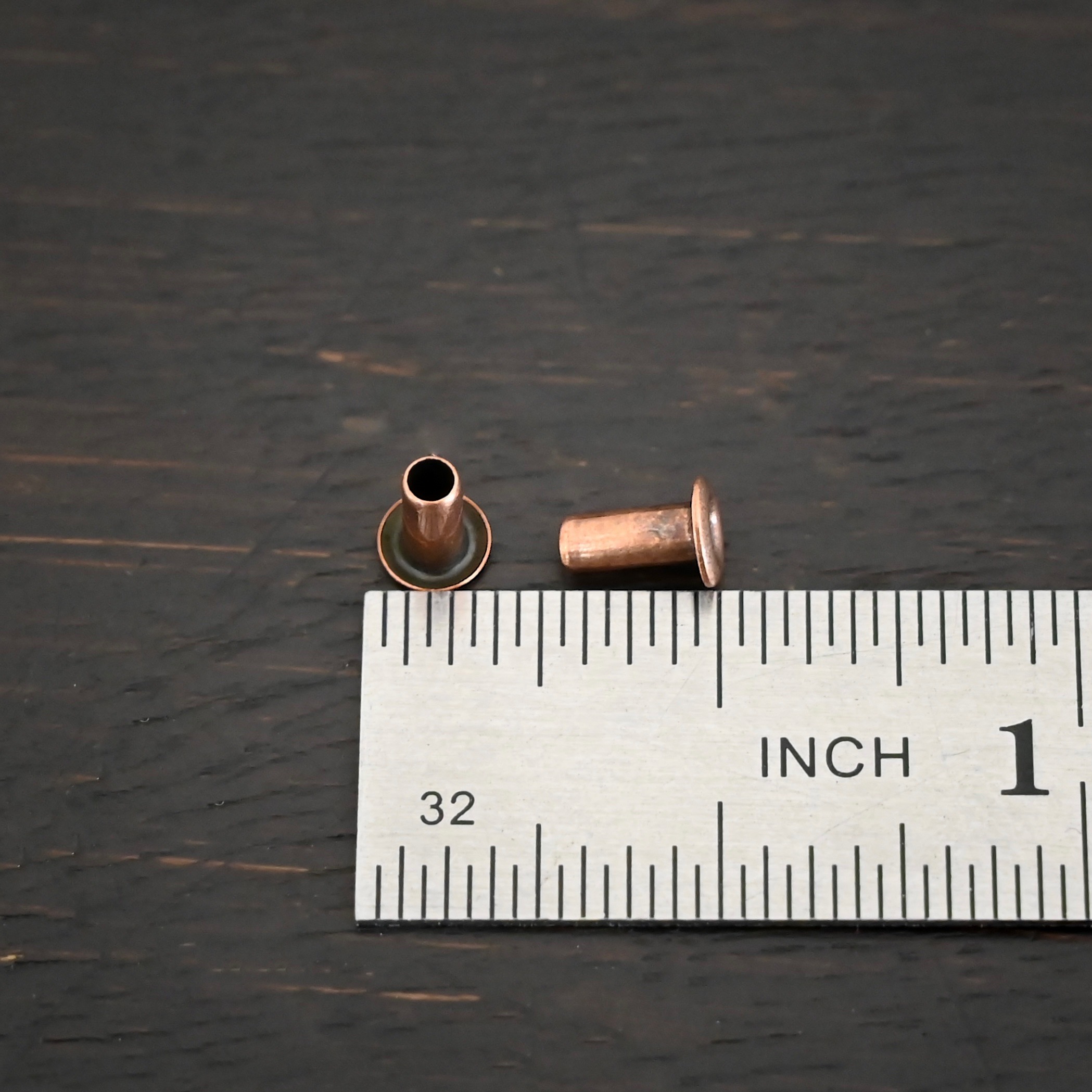 3/32x1/5 Copper plated eyelets shown by ruler