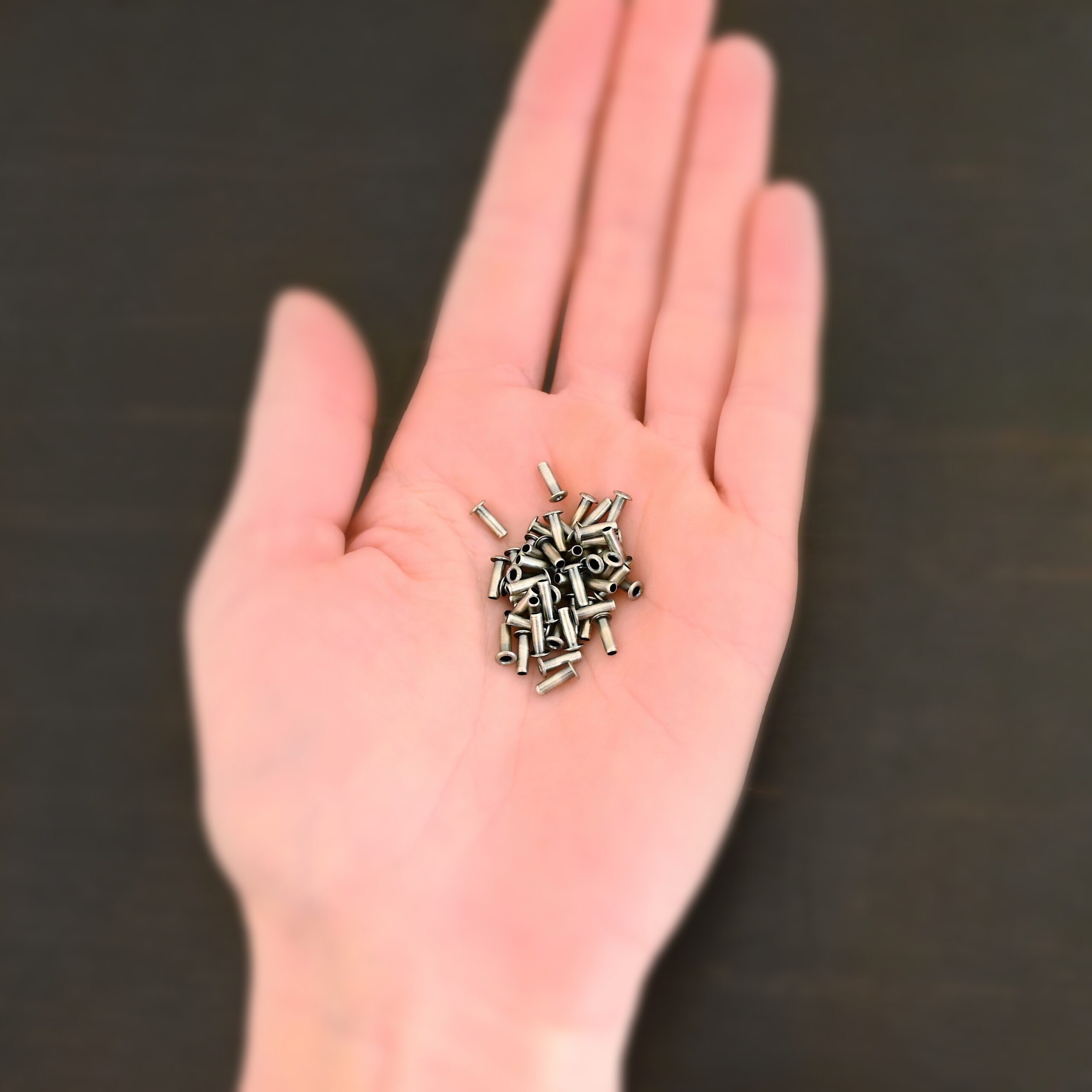 3/32x1/4 plated antique silver eyelets shown in hand