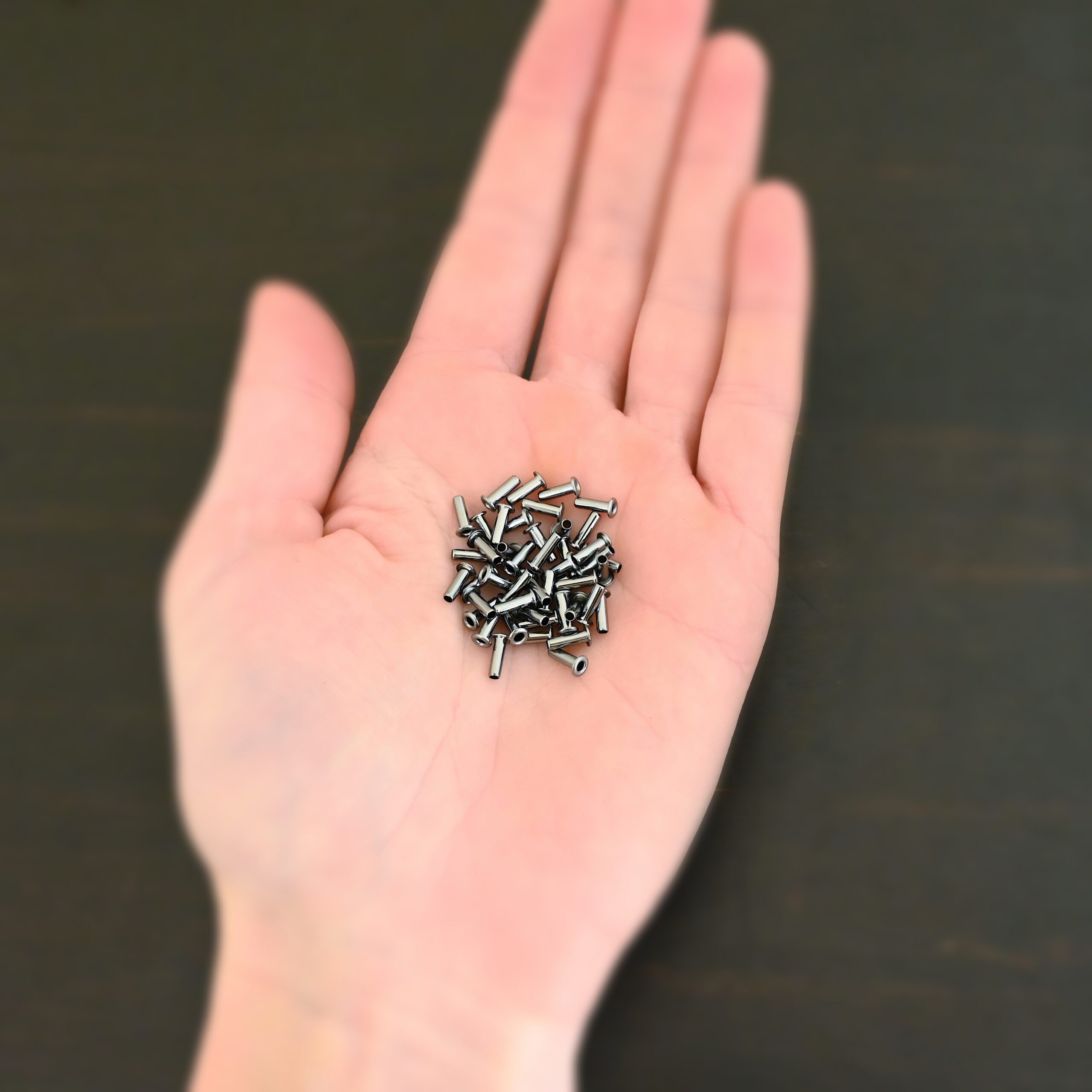 3/32x1/4 plated gunmetal eyelets shown in hand