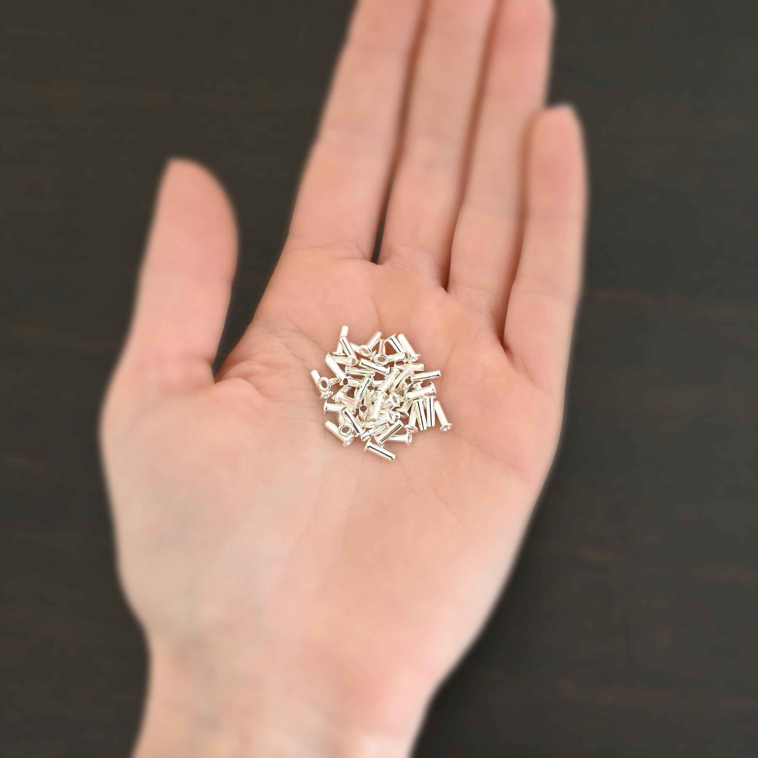 3/32x1/4 plated silver eyelets shown in hand