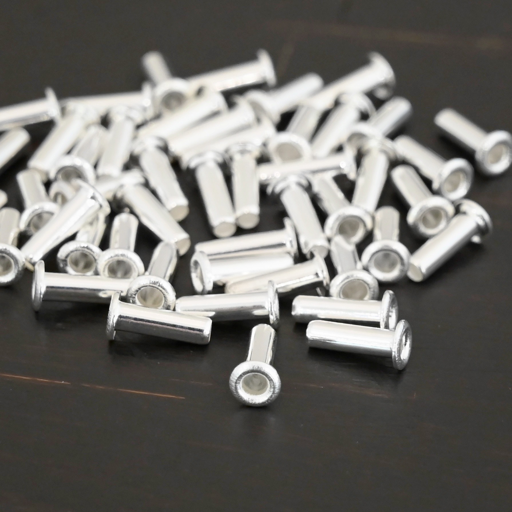 3/32x1/4 plated silver eyelets shown on dark background