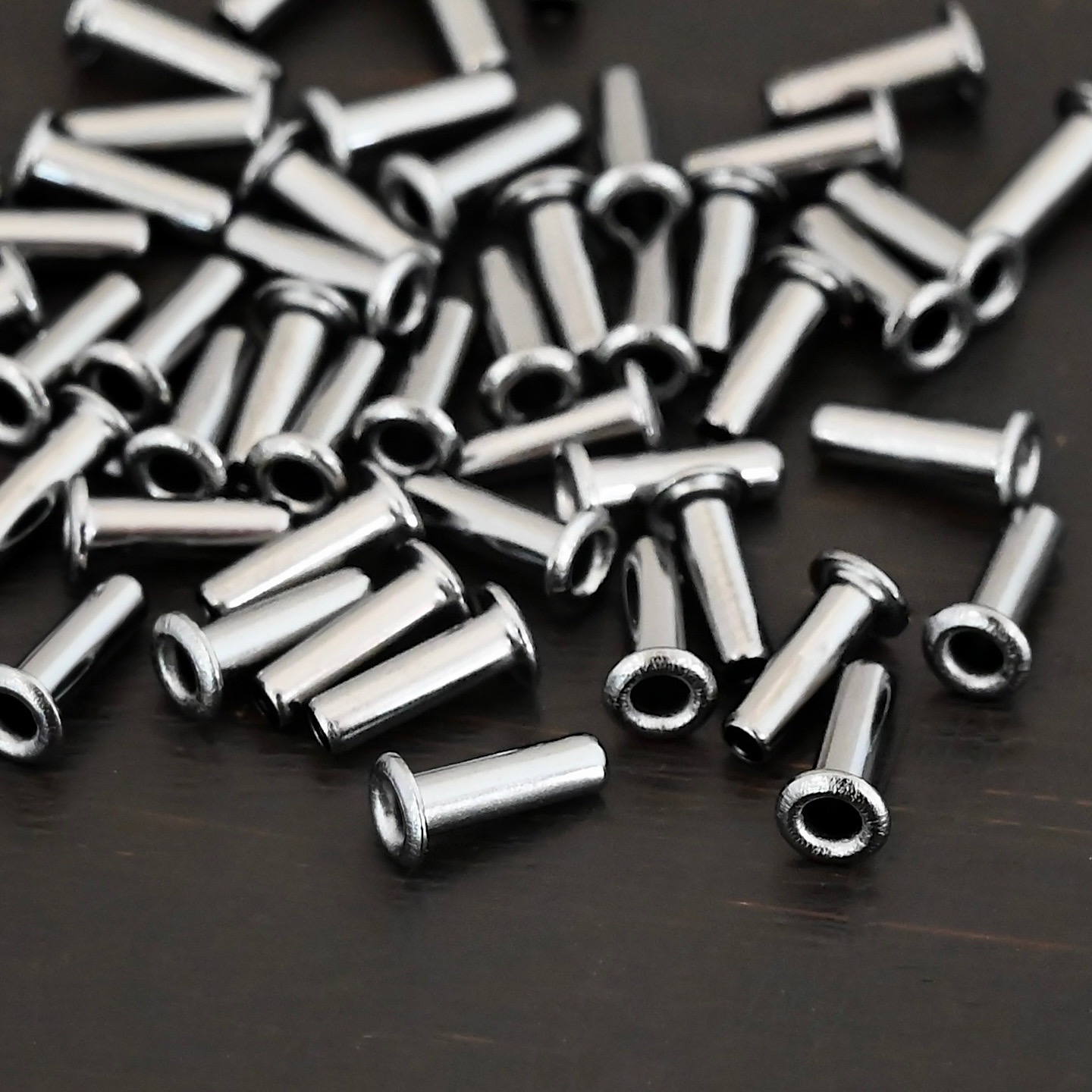 3/32x1/4 plated gunmetal eyelets shown on dark background