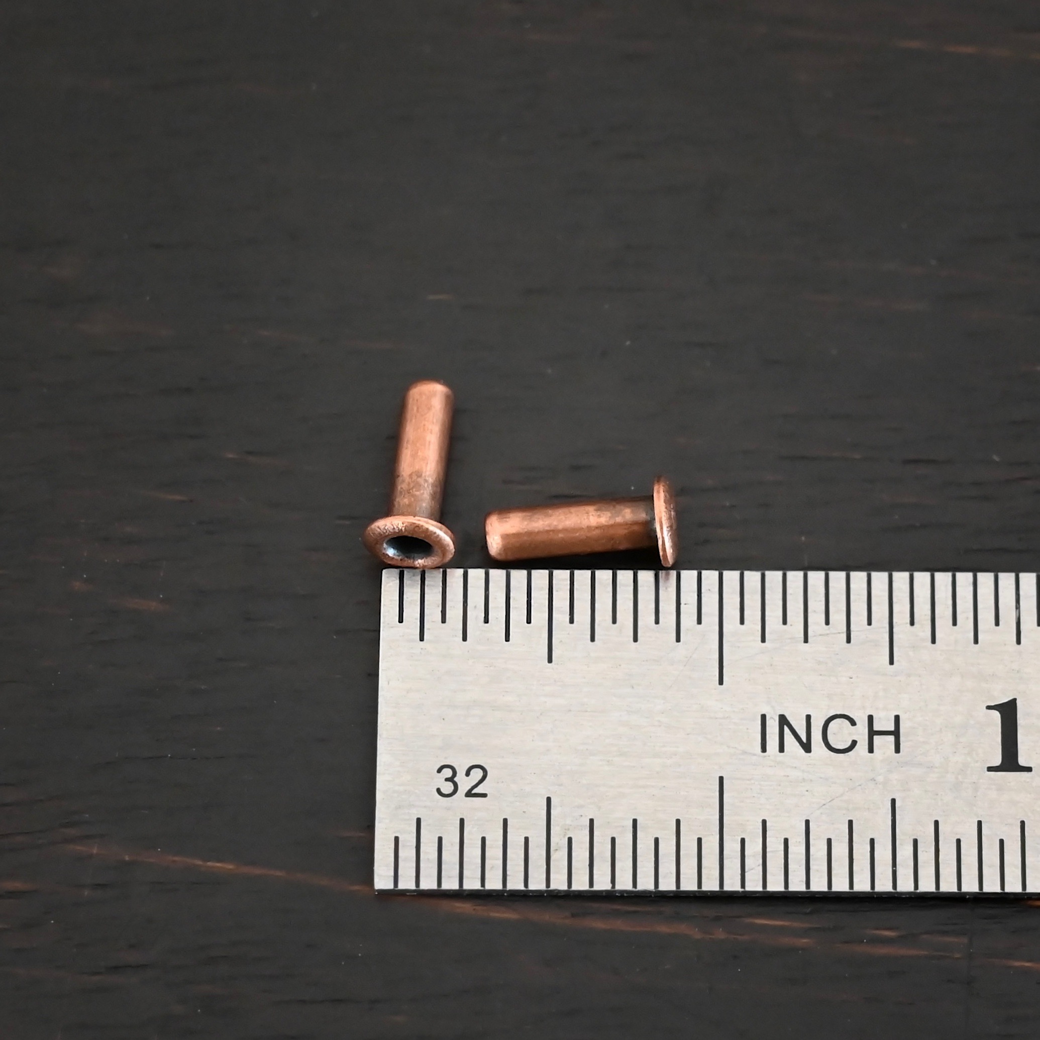 3/32x1/4 plated copper eyelets shown by ruler