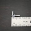 3/32x1/4 plated gunmetal eyelets shown by ruler