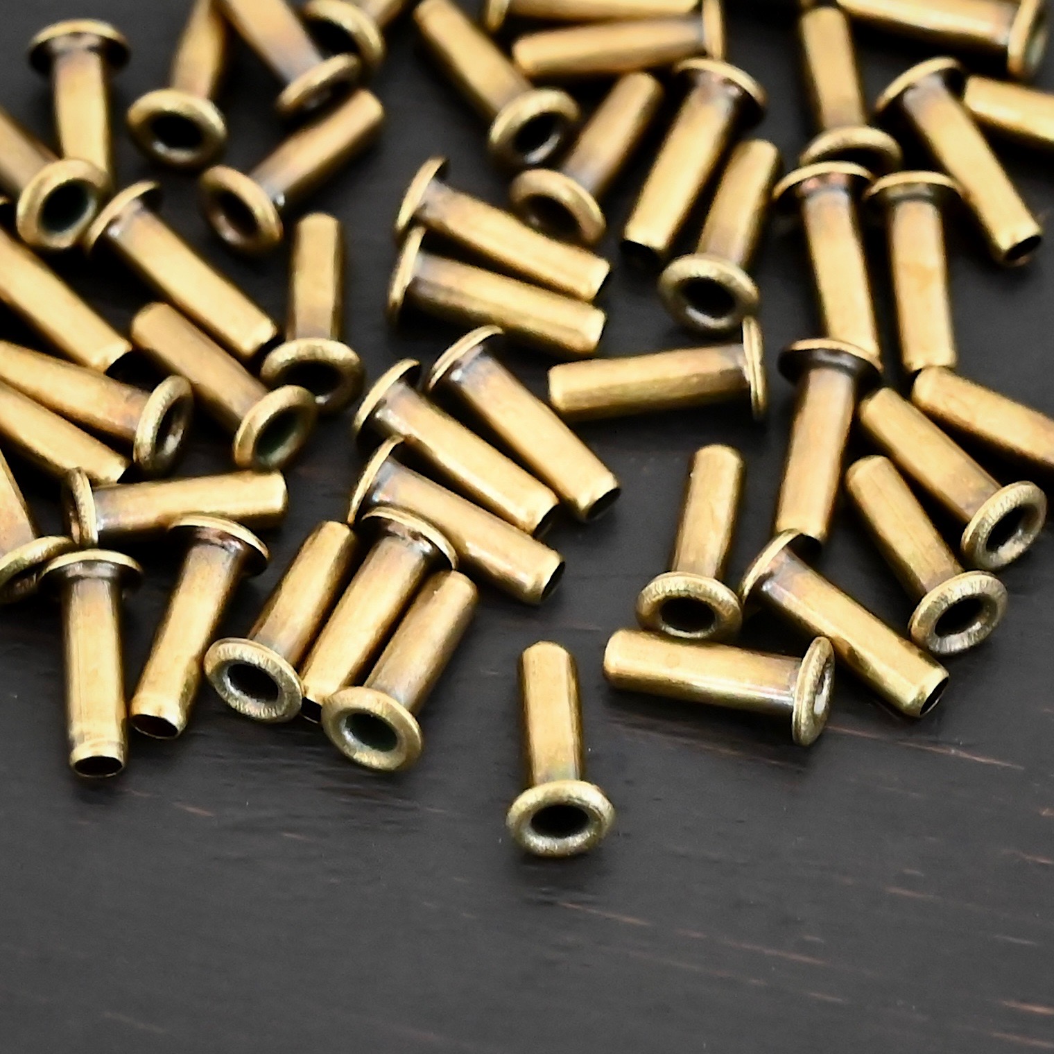 3/32x1/4 plated antique brass eyelets shown on dark background