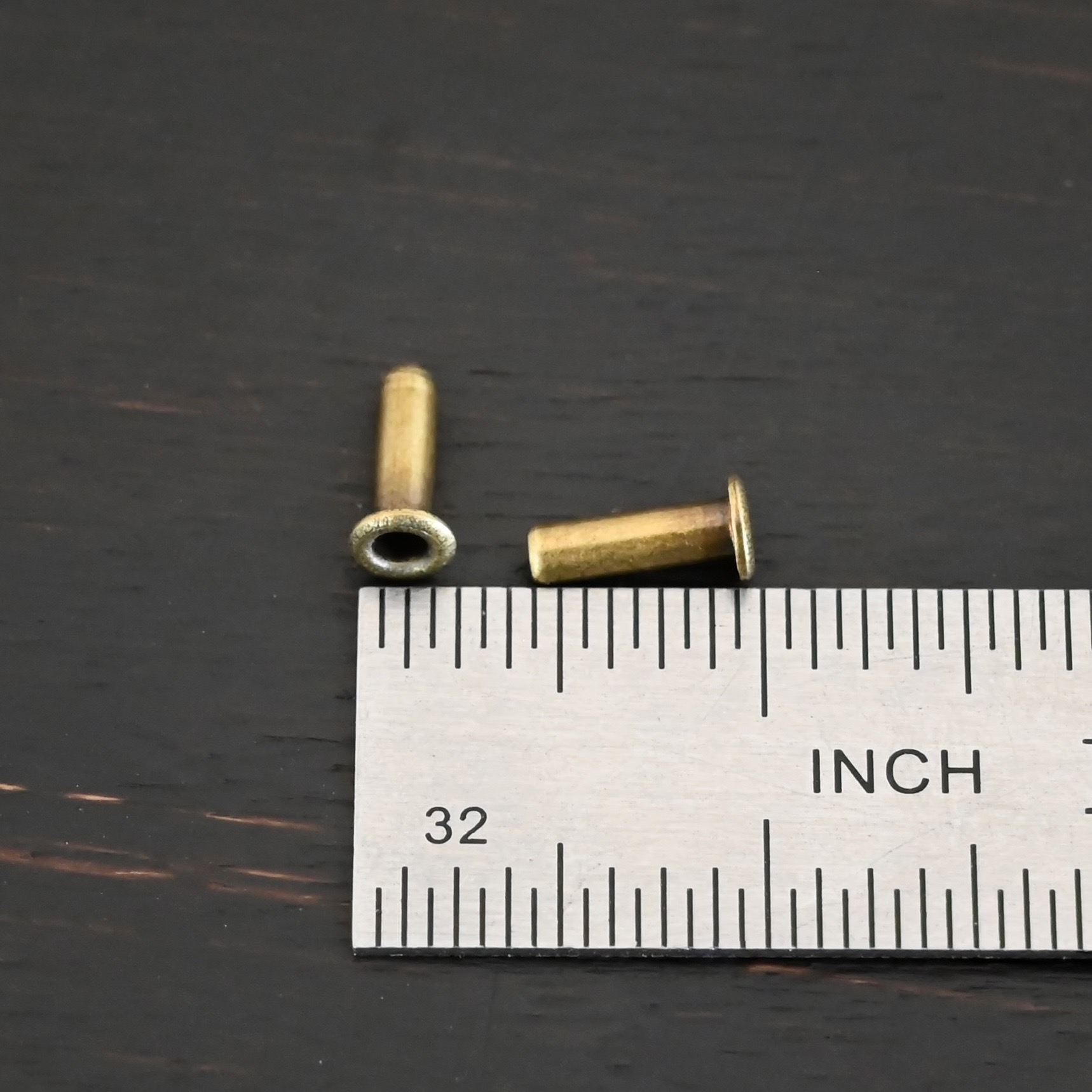 3/32x1/4 plated antique brass eyelets shown by ruler