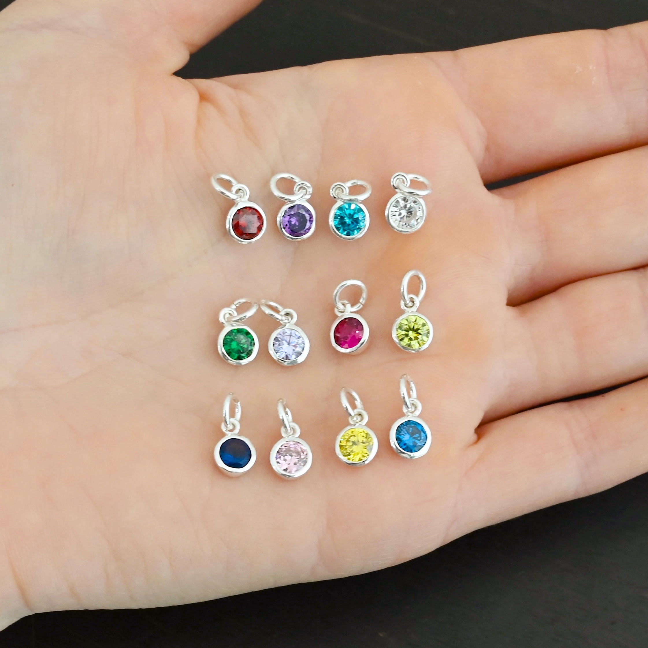 Silver 6mm Birthstone Silver Shiny 6mm Birthstone Charms shown in hand