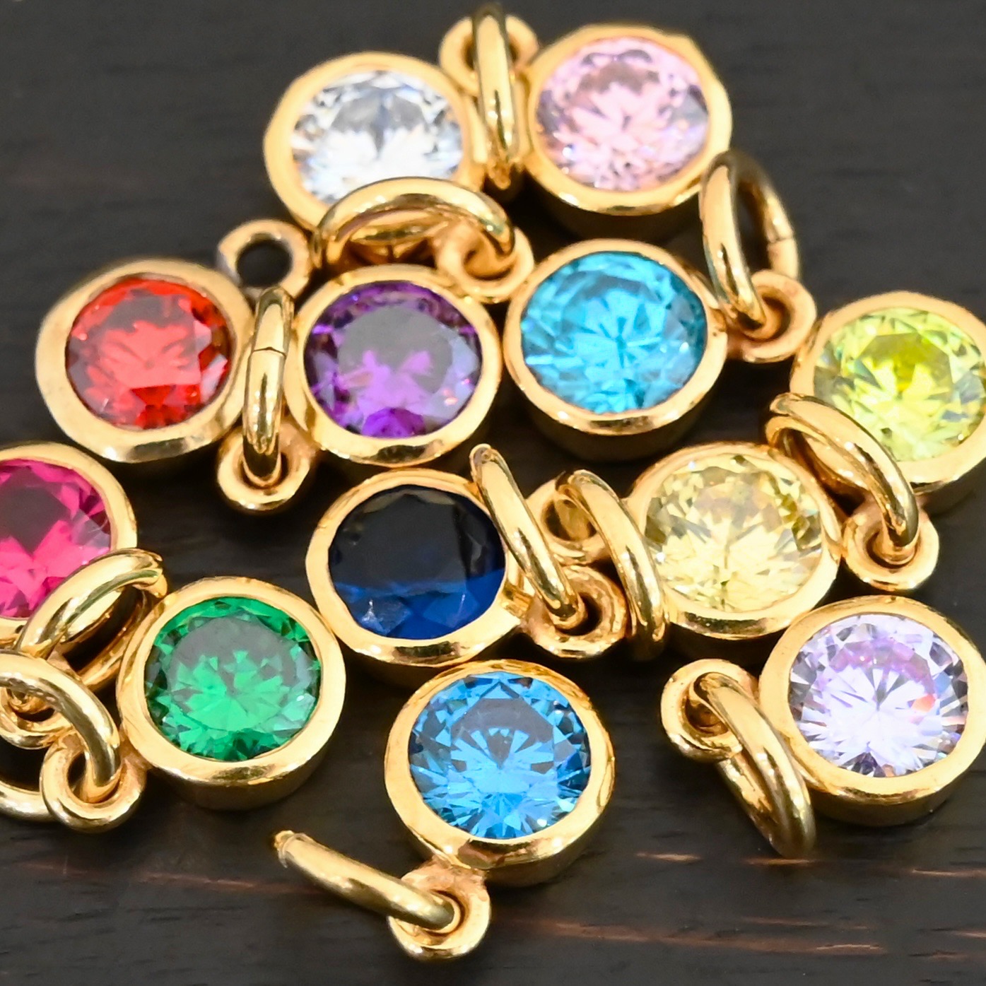 Gold Plated 6mm Birthstone Charms shown on dark background