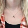 Silver barbell charm necklace shown on model