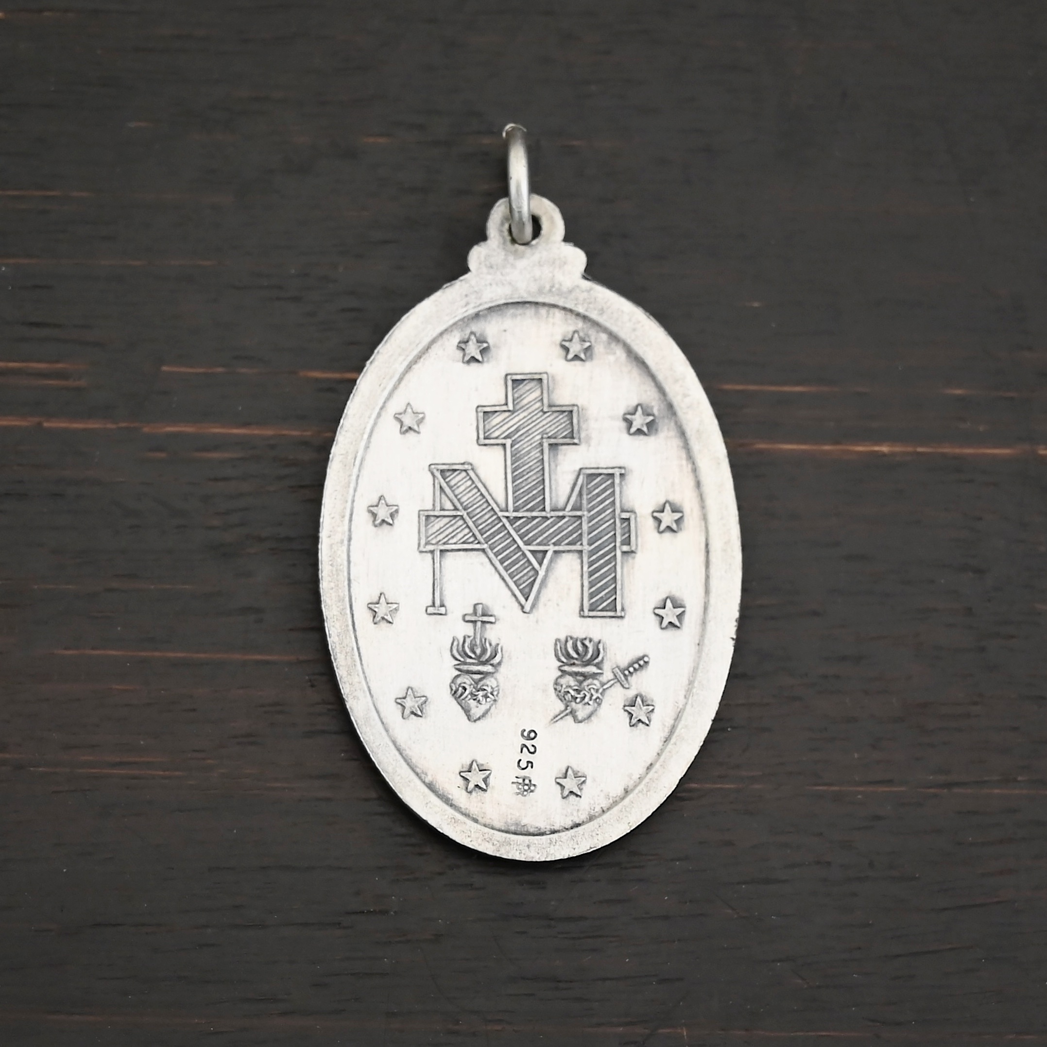 Mary Medallion Charm - 20x29mm Back side of Silver Mary Medallion Oval Charm 20x29mm on dark background