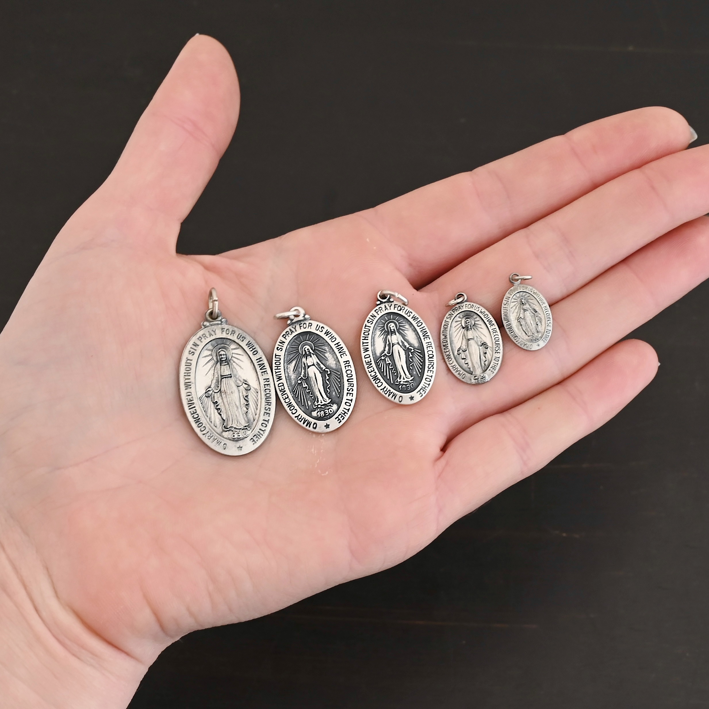Mary Medallion Charm Silver Mary Medallion Oval Charms all sizes shown in hand