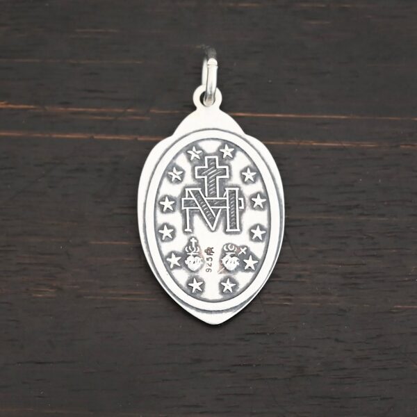 Silver back side of Mary Medallion 26x15mm charm shown on dark background
