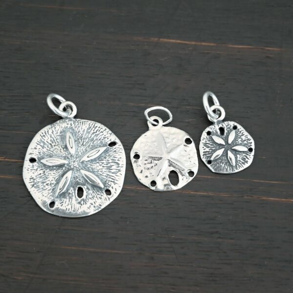 Silver Sand Dollar Charms shown on dark background